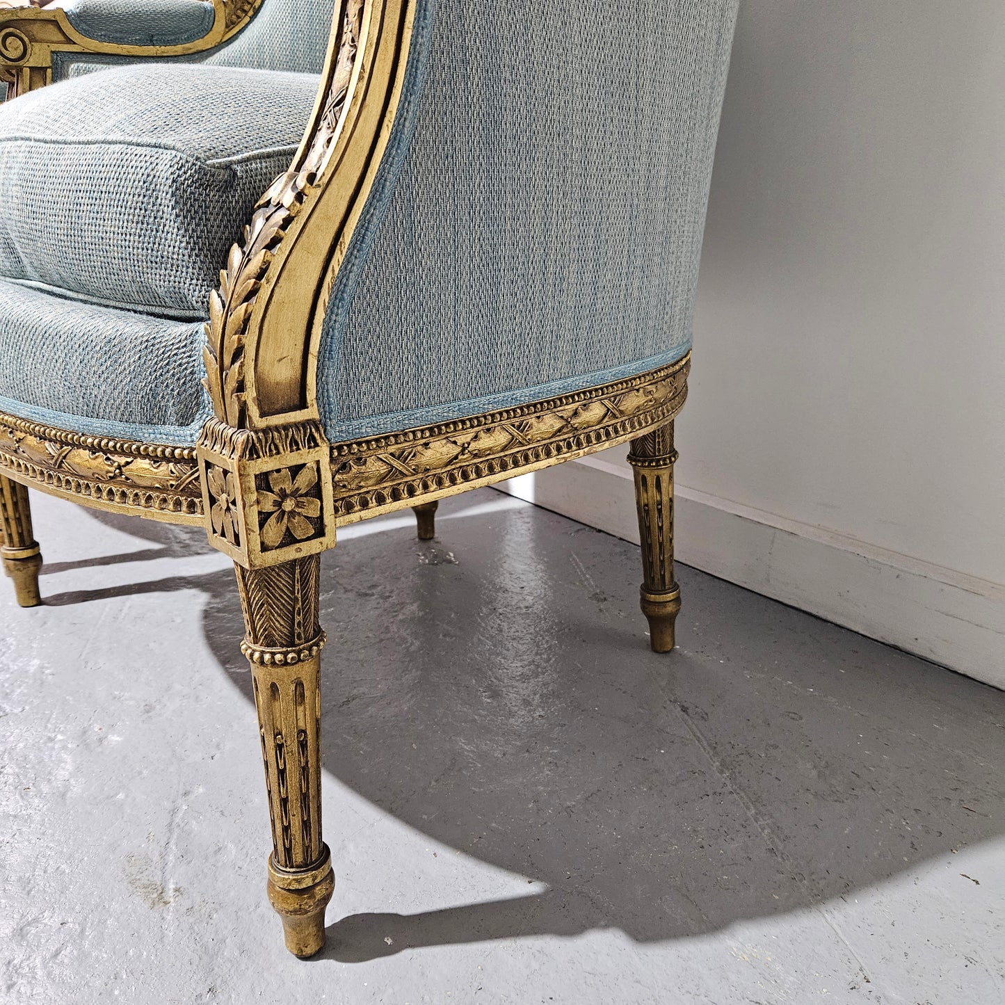Lovely pair of Louis 16th style gilt & upholstered wingback bergeres with two comfortable cushions. These chairs are in good original condition. Please view photos as they form part of the description.