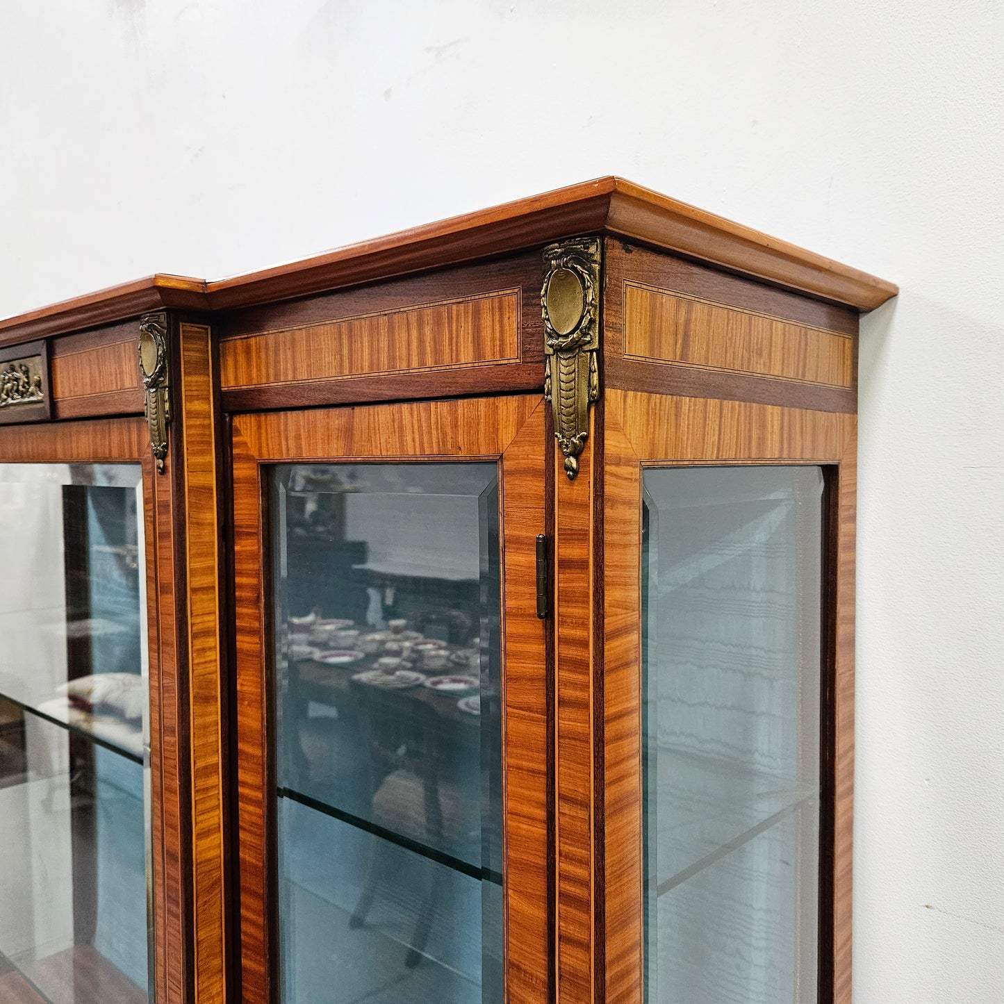 Elegant three door Louis XV transitional style vitrine with decorative bronze mounts. This unit has two glass shelves and one wooden shelf providing plenty of storage. It is in great original detailed condition. Please see the photos as they form part of the description.