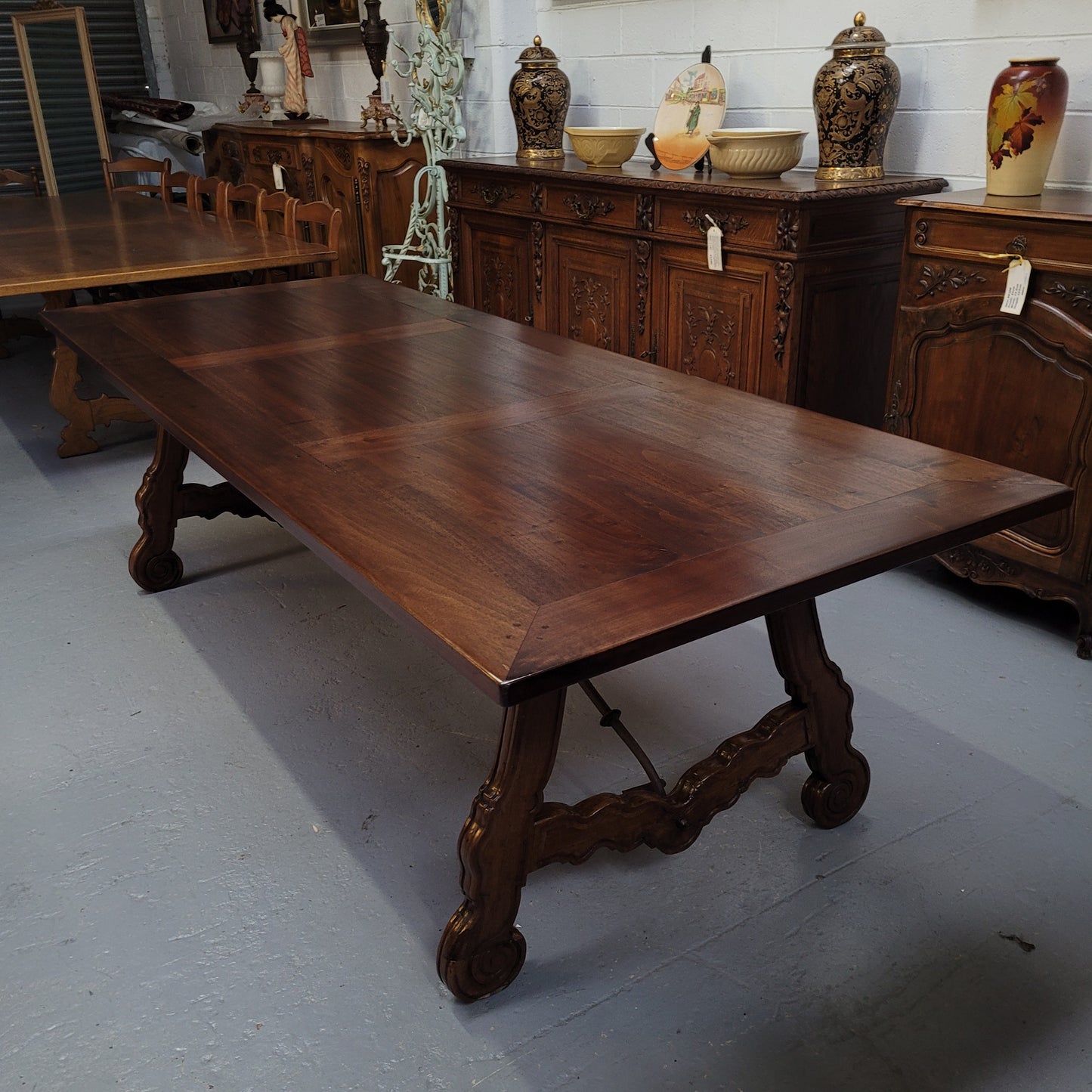 This exquisite 2.5m-long dark oak Spanish style dining table showcases exceptional ironwork underneath and is sourced from France, it is in good original detailed condition