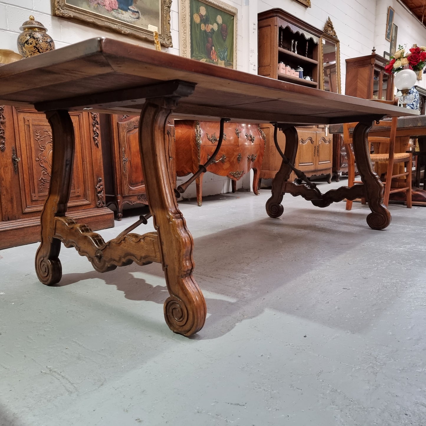 This exquisite 2.5m-long dark oak Spanish style dining table showcases exceptional ironwork underneath and is sourced from France, it is in good original detailed condition