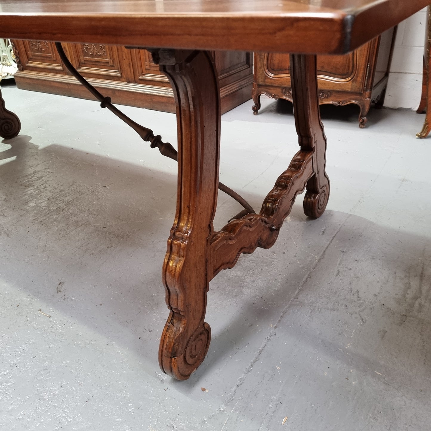 This exquisite 2.5m-long dark oak Spanish style dining table showcases exceptional ironwork underneath and is sourced from France, it is in good original detailed condition