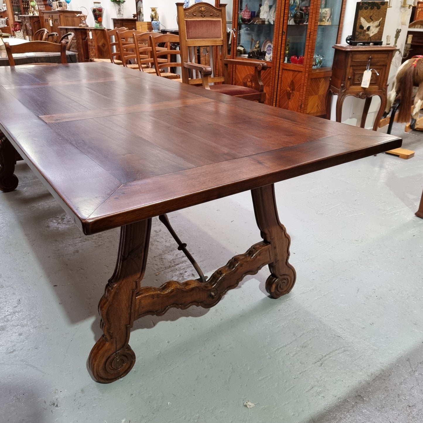 This exquisite 2.5m-long dark oak Spanish style dining table showcases exceptional ironwork underneath and is sourced from France, it is in good original detailed condition