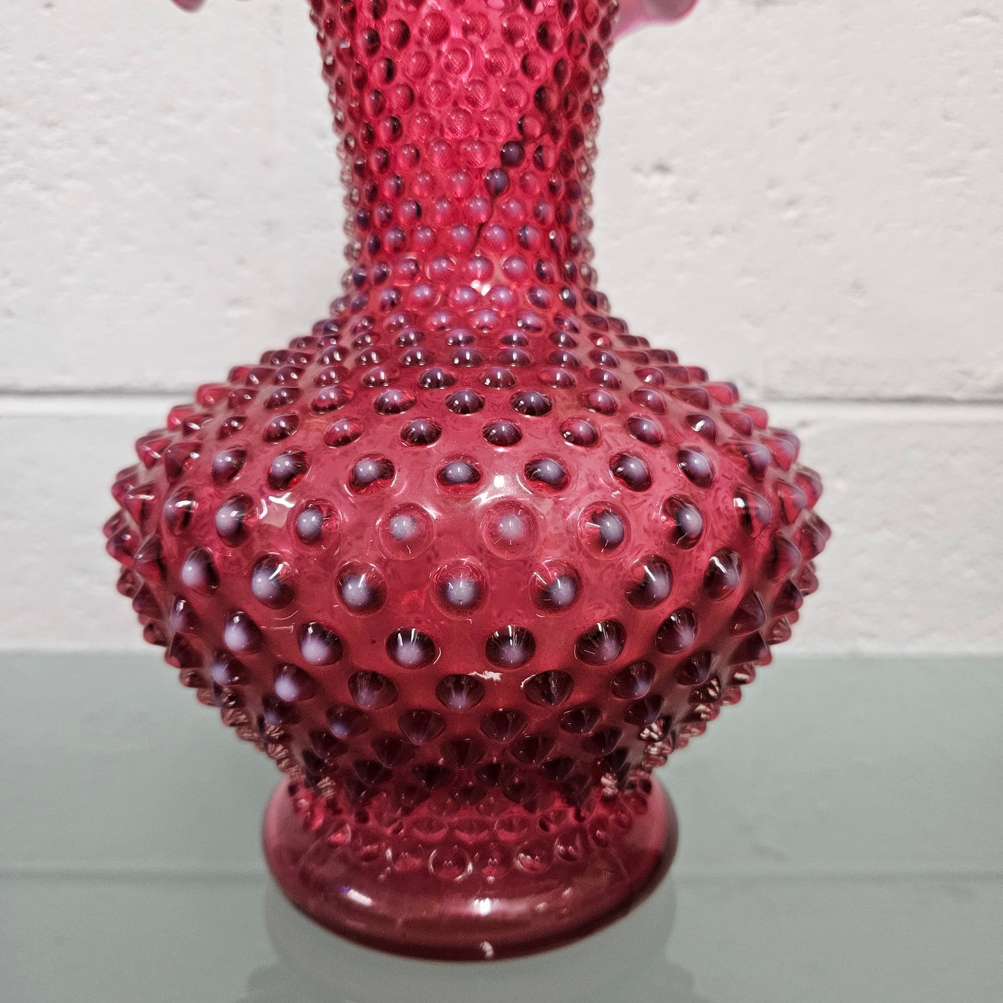 Large vintage Fenton cranberry glass vase with opalescent trim and frilled top. In good condition. Please see photos as they form part of the description.