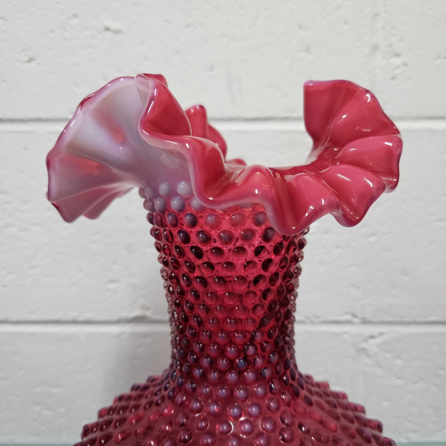 Large vintage Fenton cranberry glass vase with opalescent trim and frilled top. In good condition. Please see photos as they form part of the description.