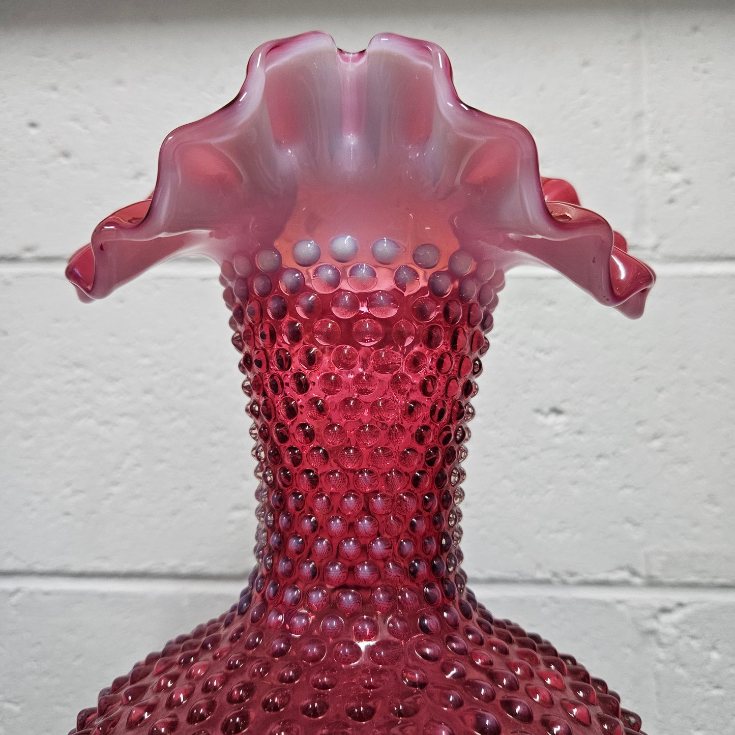 Large vintage Fenton cranberry glass vase with opalescent trim and frilled top. In good condition. Please see photos as they form part of the description.