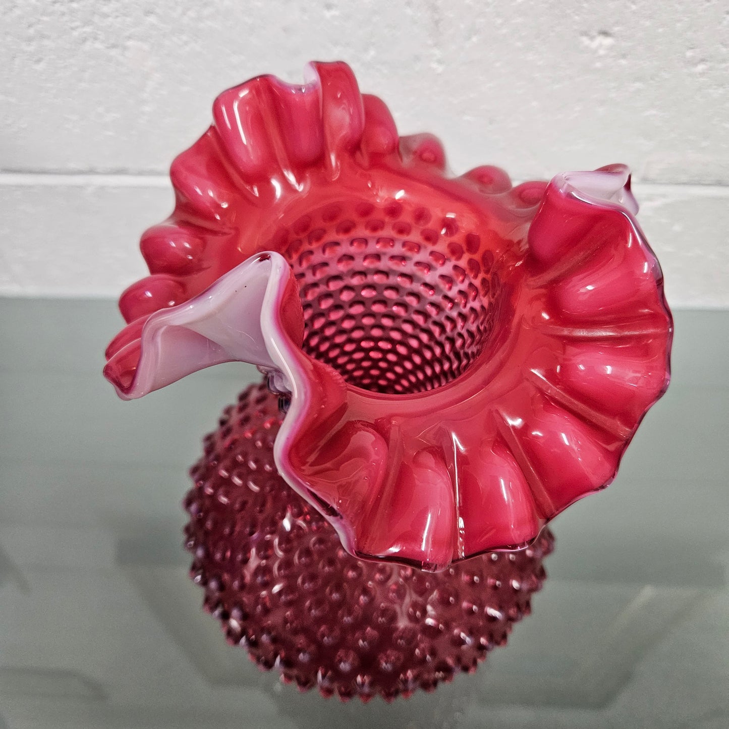Large vintage Fenton cranberry glass vase with opalescent trim and frilled top. In good condition. Please see photos as they form part of the description.