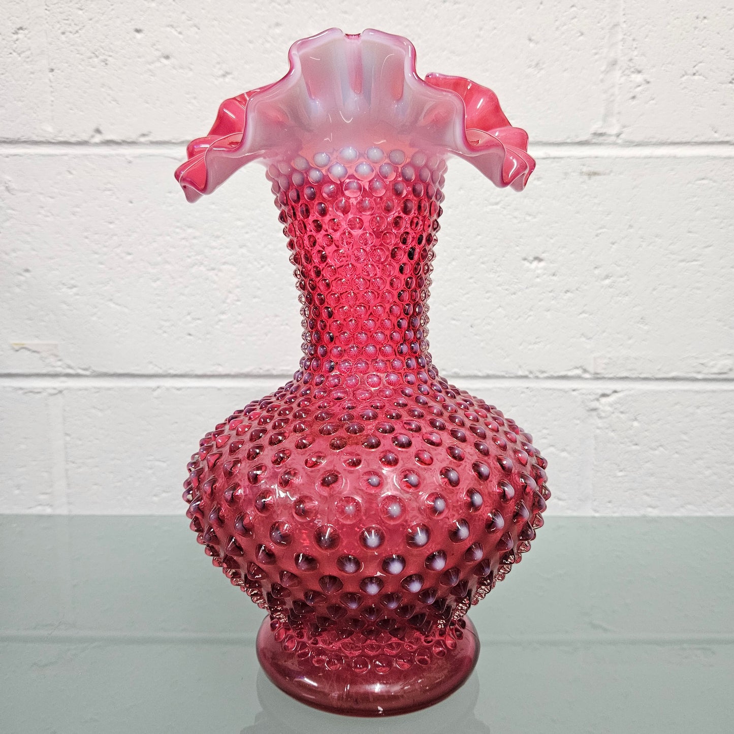 Large vintage Fenton cranberry glass vase with opalescent trim and frilled top. In good condition. Please see photos as they form part of the description.