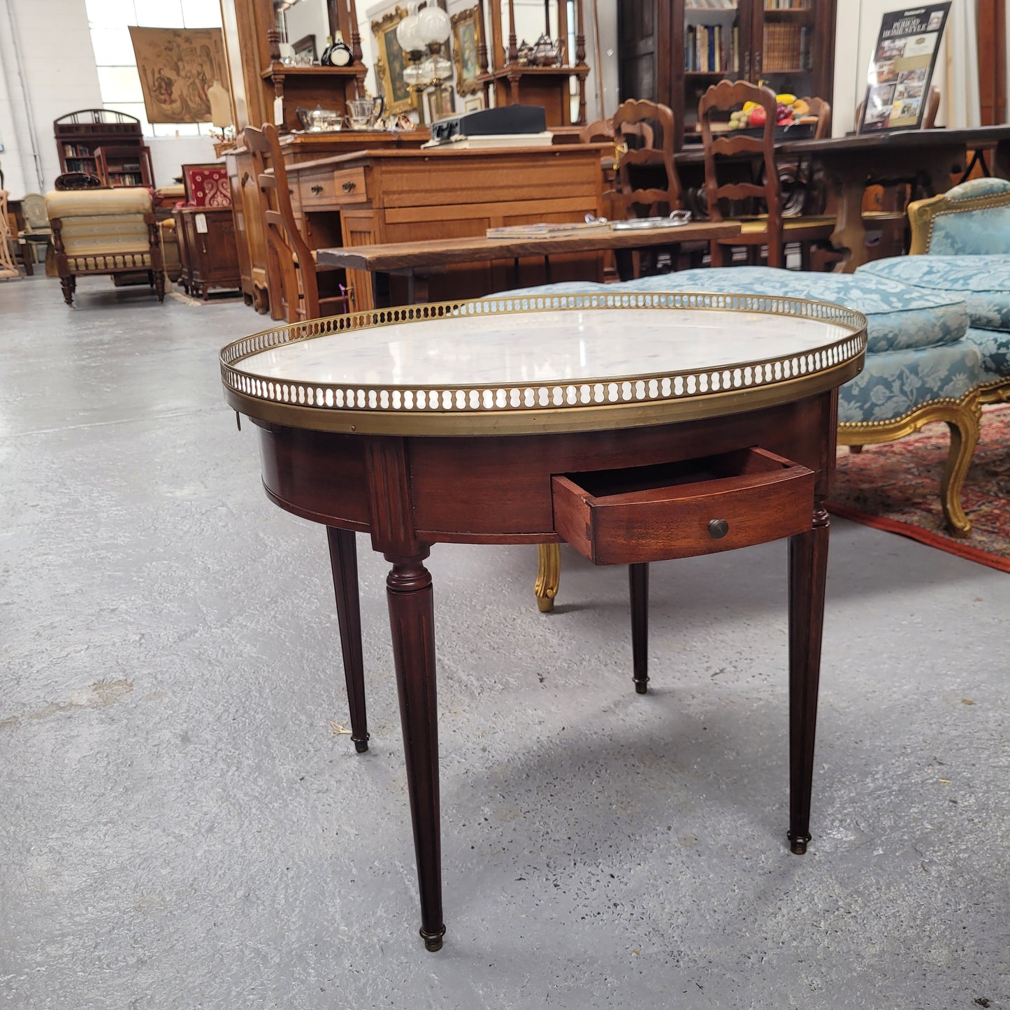 French Louis XVI style Mahogany Bouillotte table, featuring original white Carrara marble top finished nicely with a gilt brass gallery and standing on elegant tapered and fluted legs. It consists of two drawers and two slide-out extensions with leather inserts. Sourced from France and in good original detailed condition. Circa 1930.