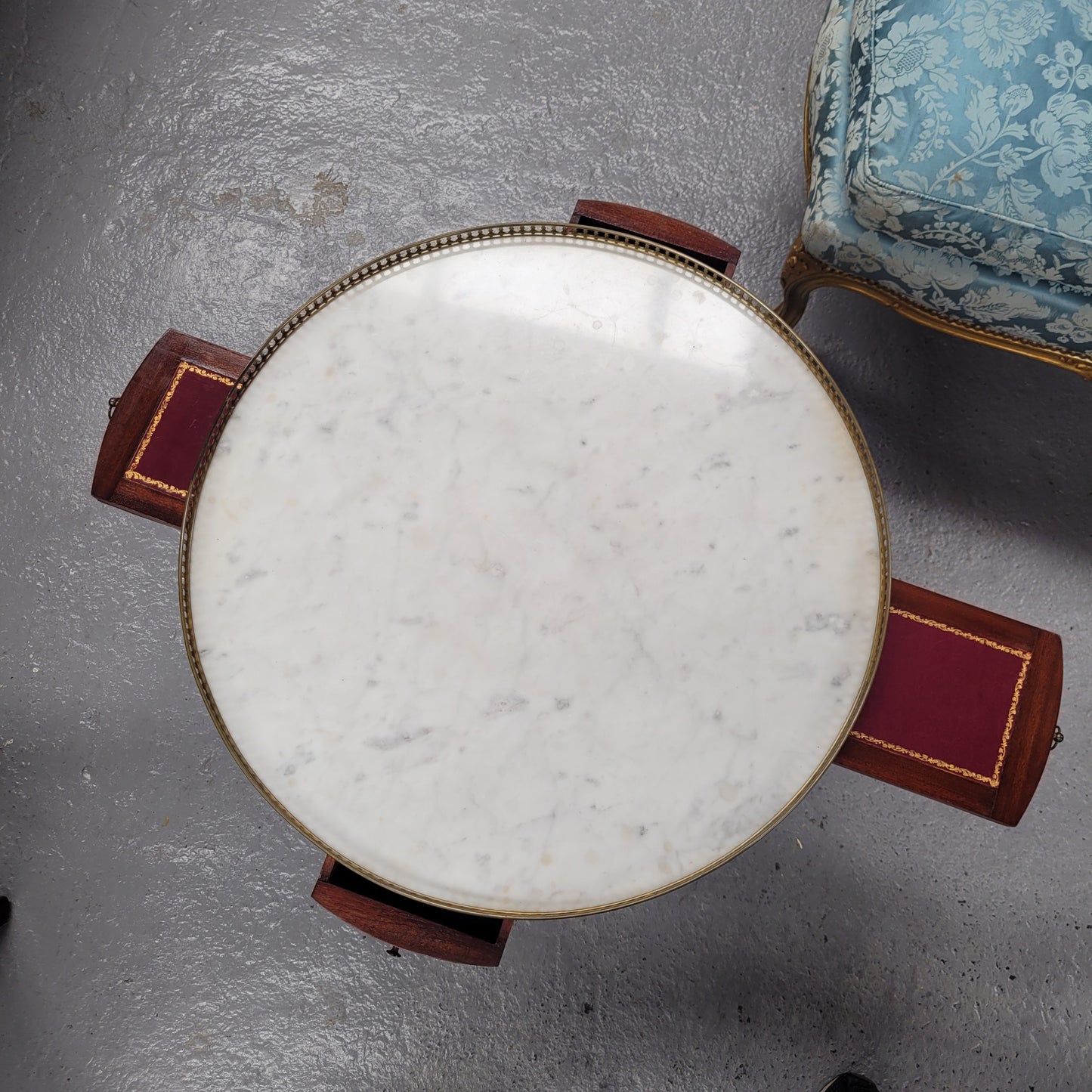 French Louis XVI style Mahogany Bouillotte table, featuring original white Carrara marble top finished nicely with a gilt brass gallery and standing on elegant tapered and fluted legs. It consists of two drawers and two slide-out extensions with leather inserts. Sourced from France and in good original detailed condition. Circa 1930.