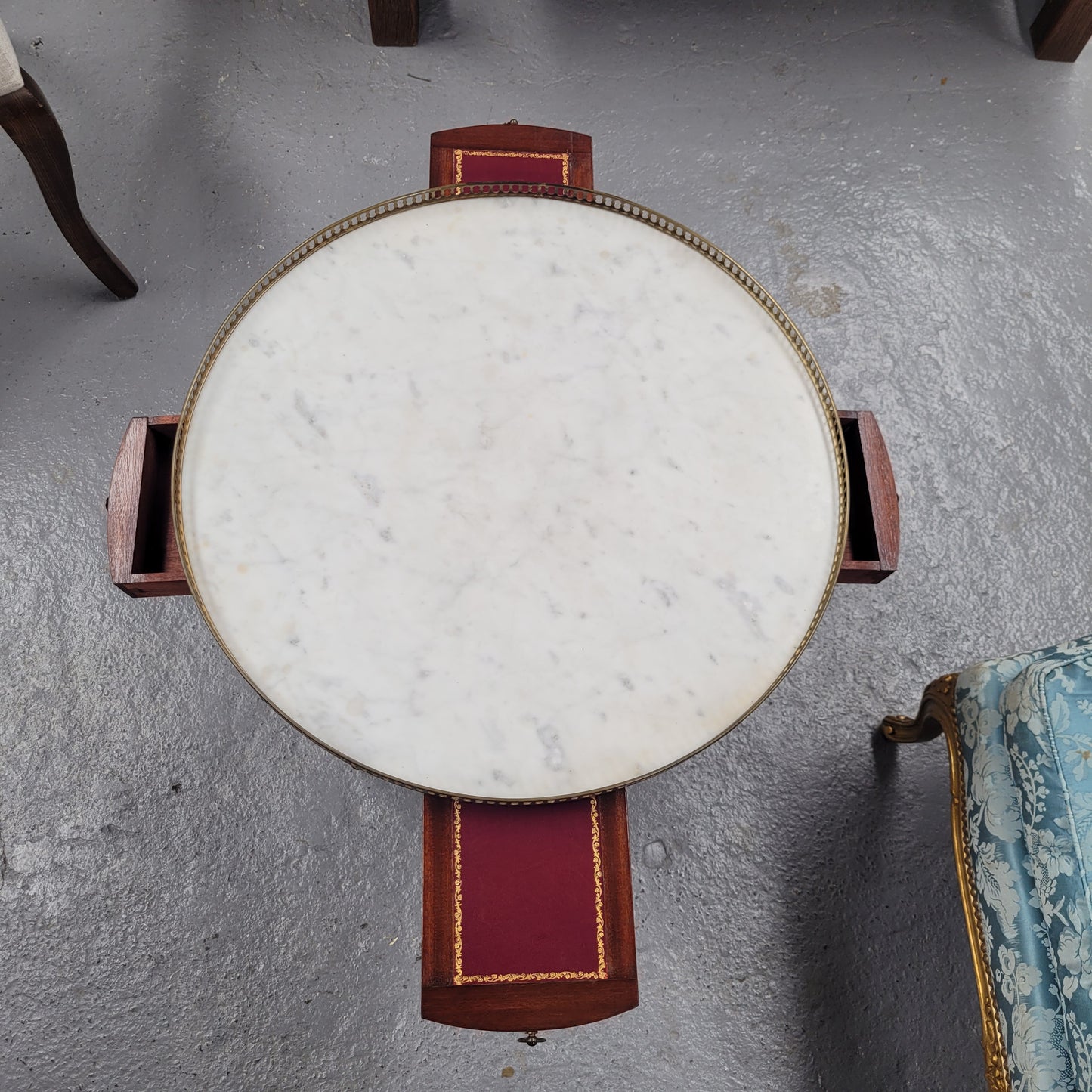 French Louis XVI style Mahogany Bouillotte table, featuring original white Carrara marble top finished nicely with a gilt brass gallery and standing on elegant tapered and fluted legs. It consists of two drawers and two slide-out extensions with leather inserts. Sourced from France and in good original detailed condition. Circa 1930.