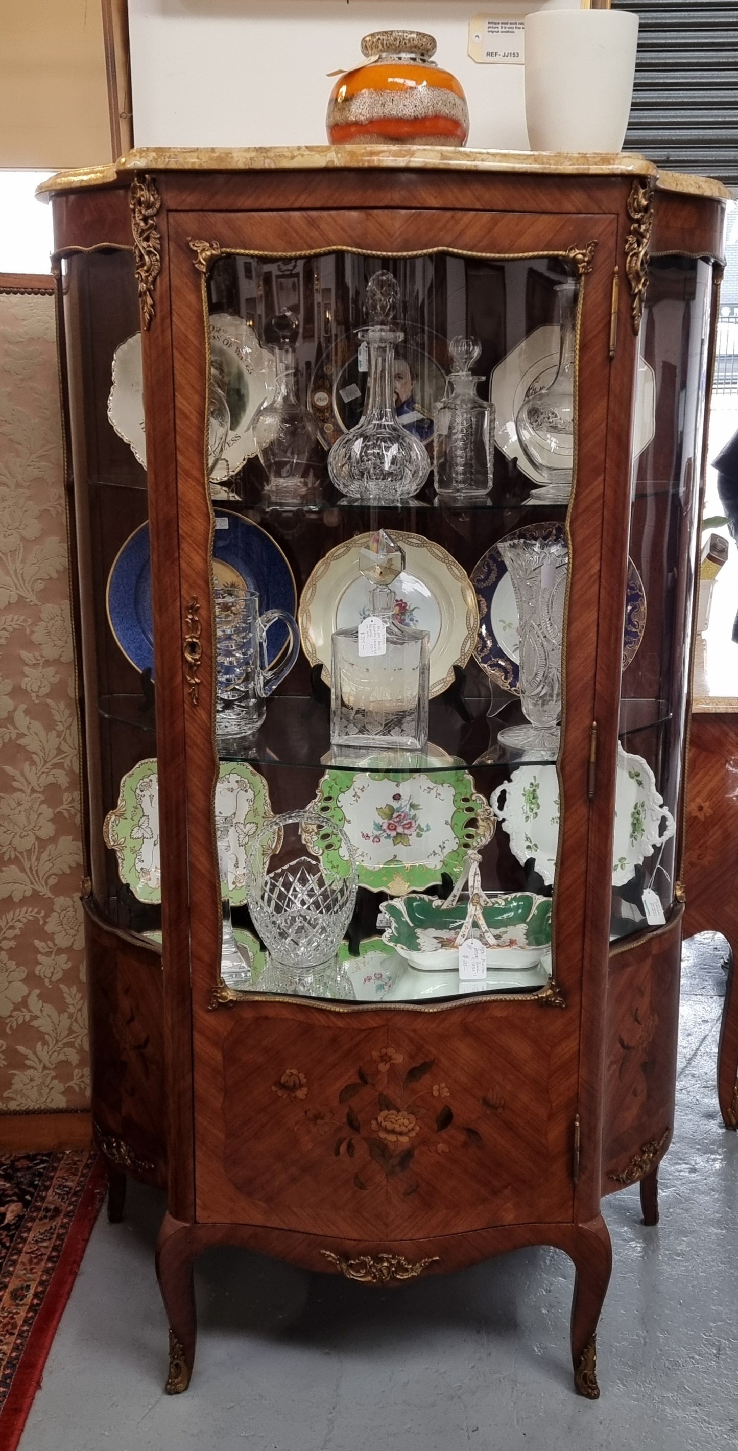 Grand French Walnut Louis XV style marble top vitrine. It has two glass shelfs and one mirrored shelf at the bottom and added storage at bottom. It is in good original detailed condition.
