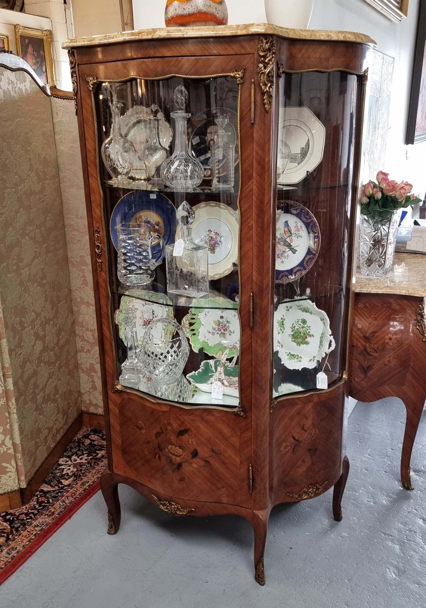 Grand French Walnut Louis XV style marble top vitrine. It has two glass shelfs and one mirrored shelf at the bottom and added storage at bottom. It is in good original detailed condition.