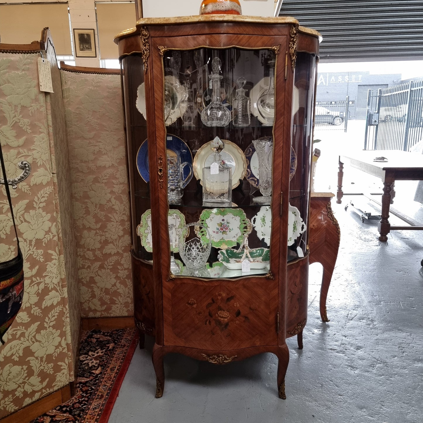 Grand French Walnut Louis XV style marble top vitrine. It has two glass shelfs and one mirrored shelf at the bottom and added storage at bottom. It is in good original detailed condition.