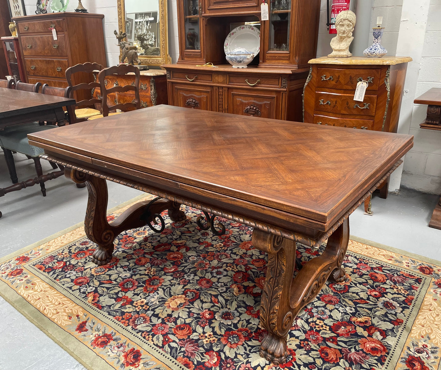 Beautiful French Oak Spanish style extension dining table with a decorative iron base and parquetry top. Lovely carvings on the legs and the skirt of the base. With the extensions closed it is 160 cm long and when fully extended it is 268 cm long. It has been sourced from France and in good original condition.