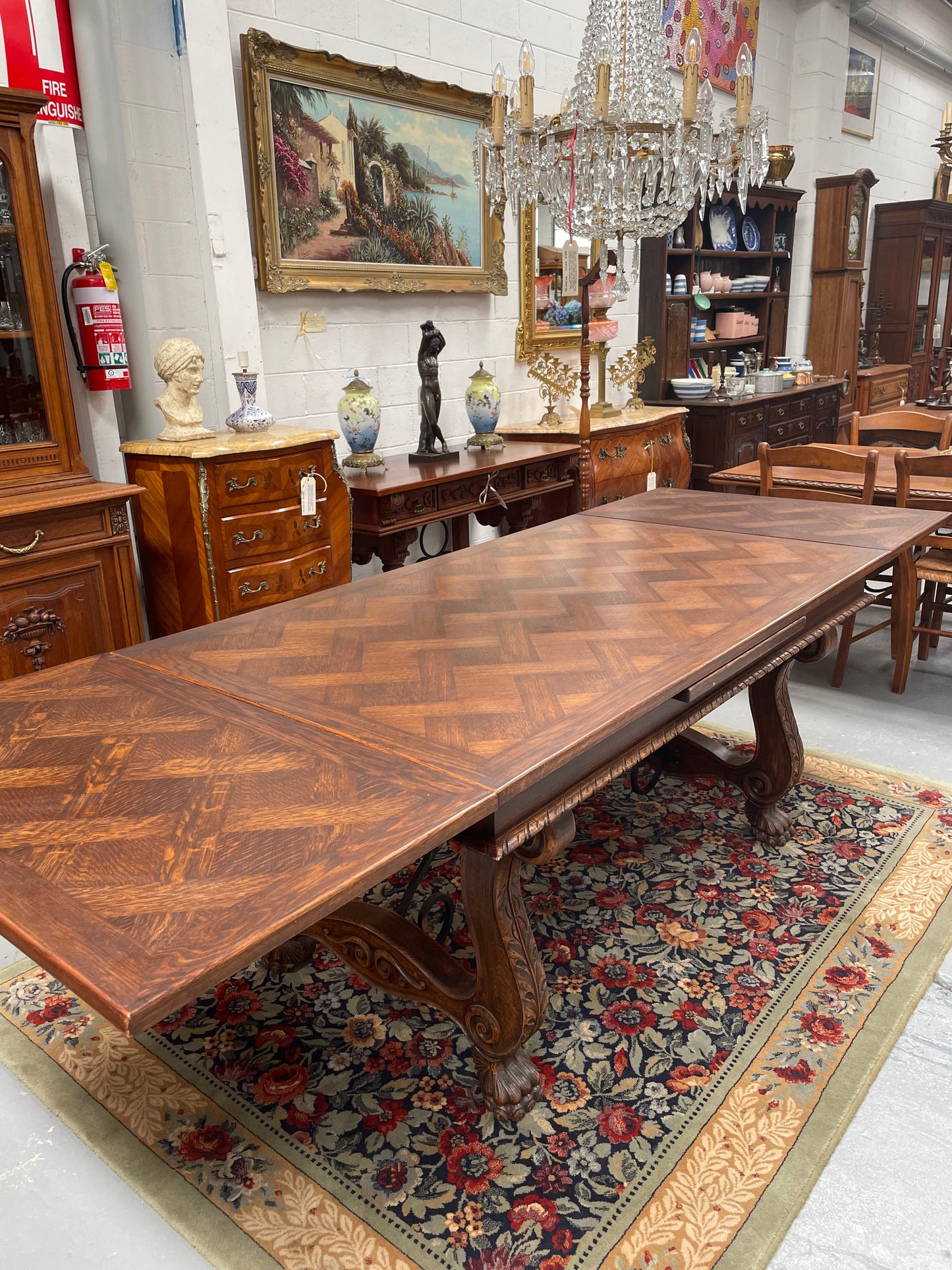 Beautiful French Oak Spanish style extension dining table with a decorative iron base and parquetry top. Lovely carvings on the legs and the skirt of the base. With the extensions closed it is 160 cm long and when fully extended it is 268 cm long. It has been sourced from France and in good original condition.