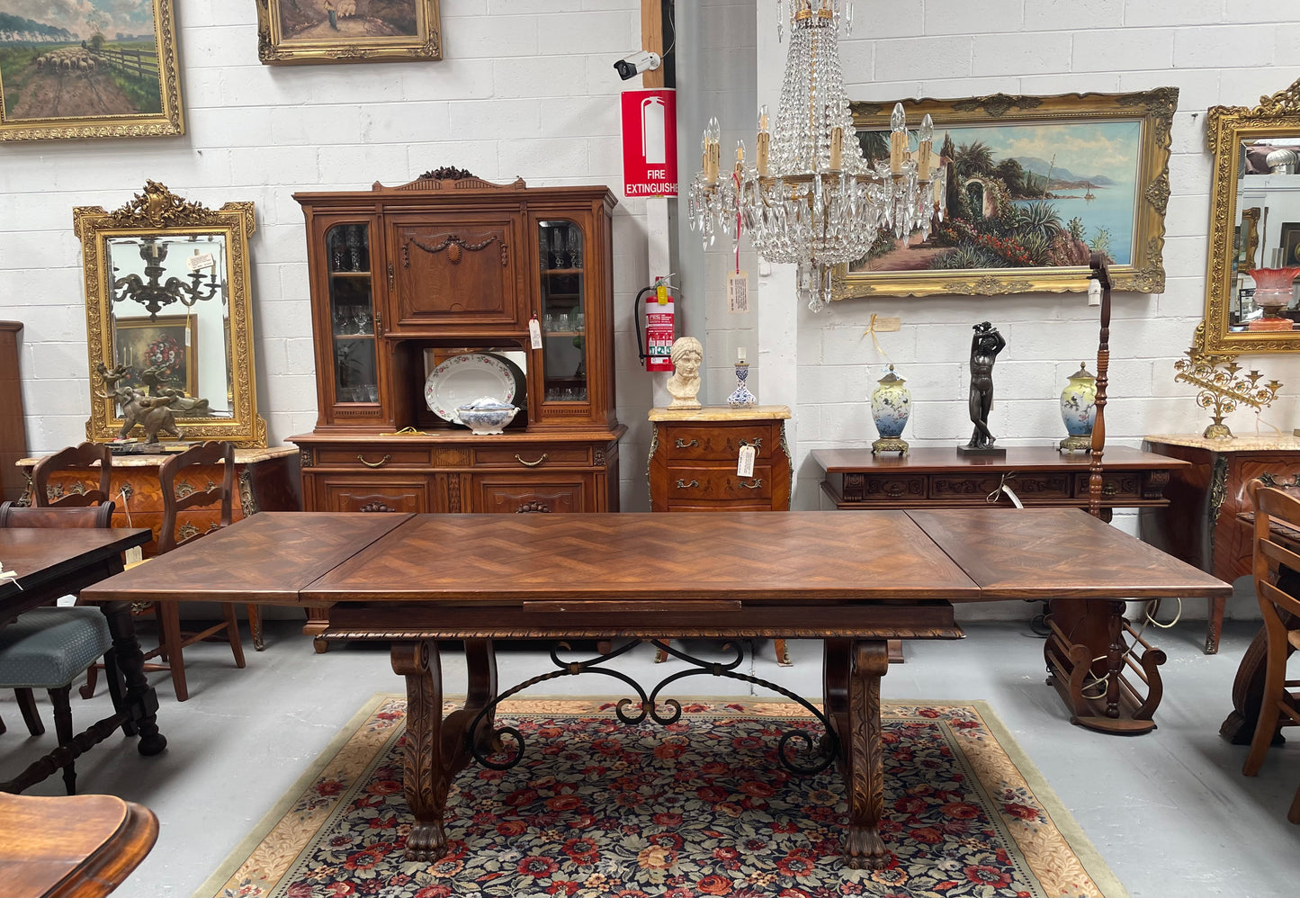 Beautiful French Oak Spanish style extension dining table with a decorative iron base and parquetry top. Lovely carvings on the legs and the skirt of the base. With the extensions closed it is 160 cm long and when fully extended it is 268 cm long. It has been sourced from France and in good original condition.