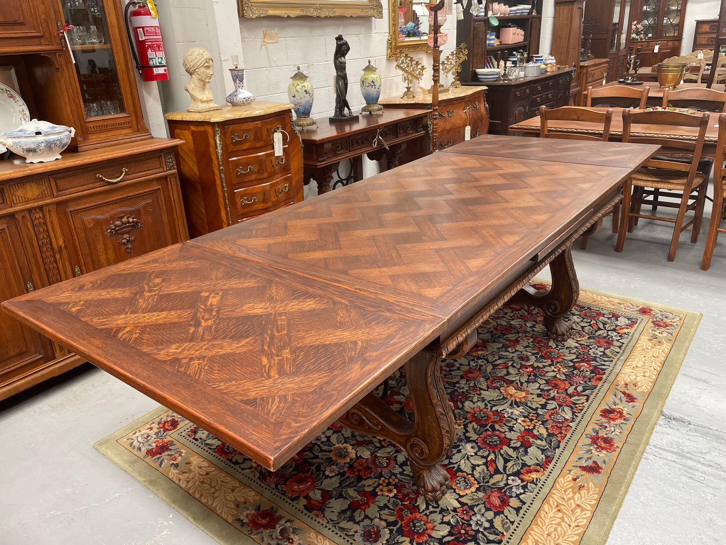 Beautiful French Oak Spanish style extension dining table with a decorative iron base and parquetry top. Lovely carvings on the legs and the skirt of the base. With the extensions closed it is 160 cm long and when fully extended it is 268 cm long. It has been sourced from France and in good original condition.