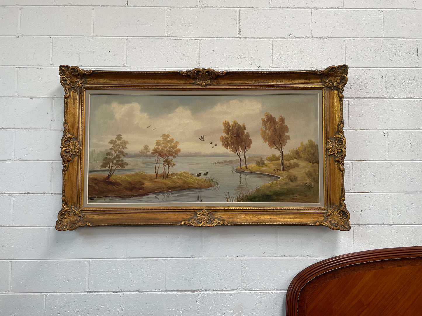 Beautiful large French oil on canvas landscape of a peaceful river scene featuring ducks and trees in a ornate gold frame. Sourced from France and in good original condition.