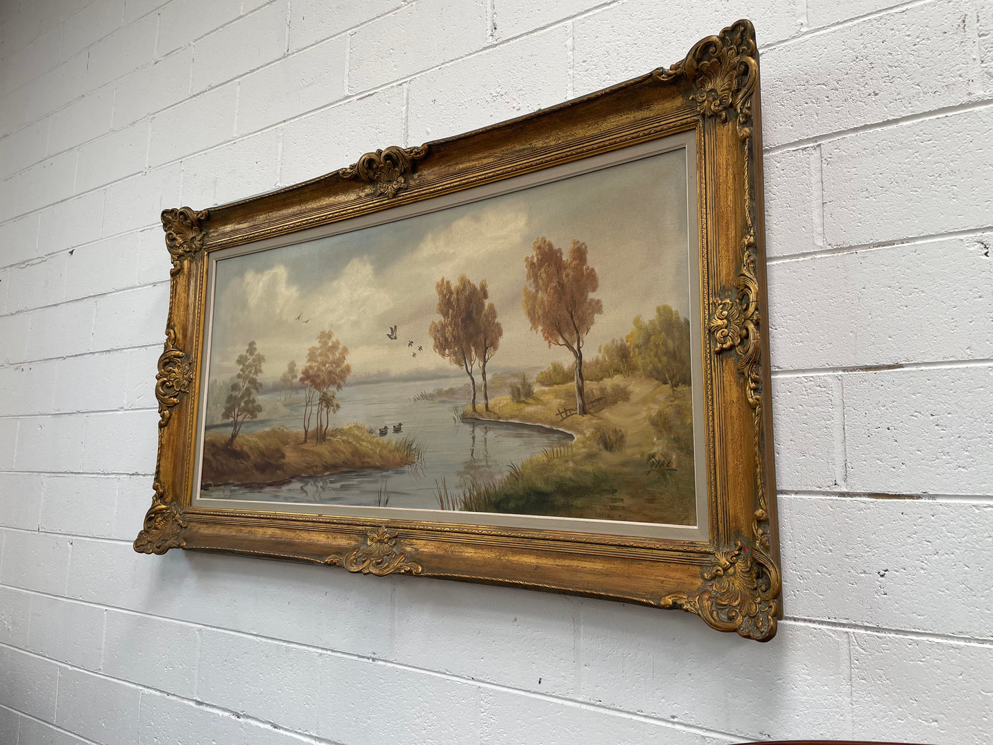 Beautiful large French oil on canvas landscape of a peaceful river scene featuring ducks and trees in a ornate gold frame. Sourced from France and in good original condition.