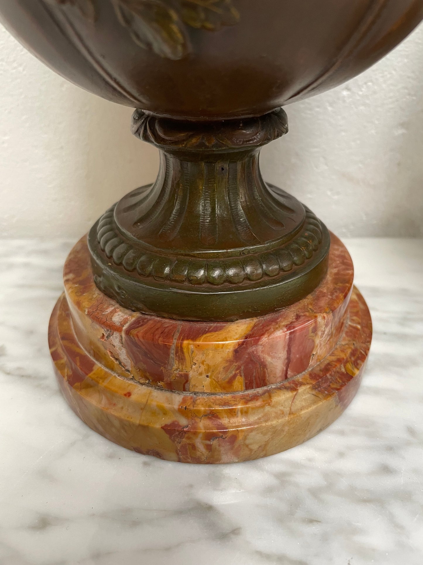 Pair of French Bronzed Metal Cherub Urns on a Marble Base