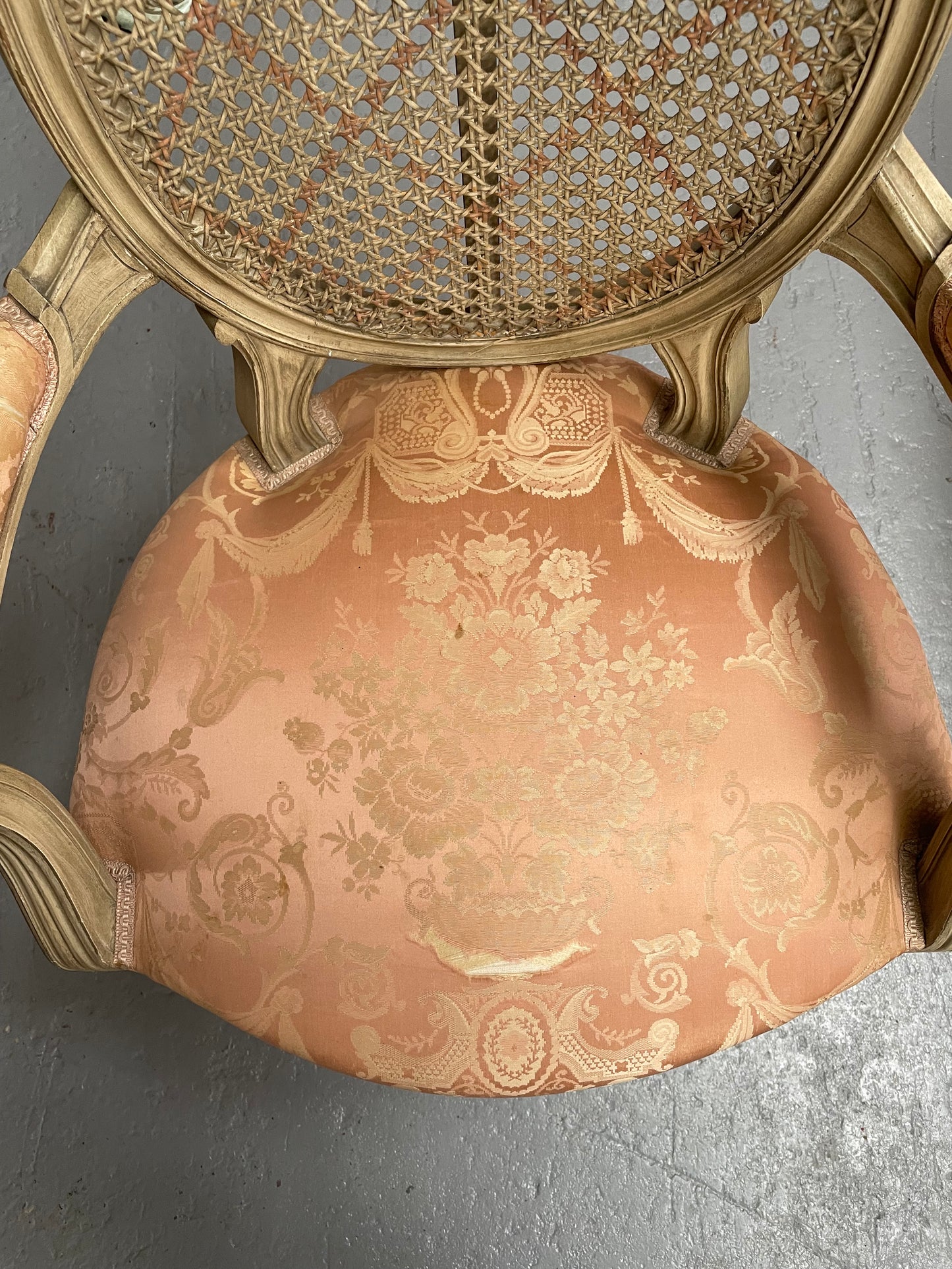 French Louis XV style cane back and upholstered seat fauteuil. With original paint and fabric is in original used condition with some stains and tears. Overall they are in good original used condition. Circa 1950's.