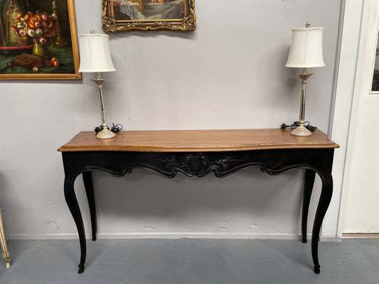 Louis XV style long console table with an ebonized black base and timber top. It is in good original detailed condition and has been sourced directly from France.
