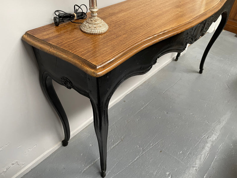 Louis XV style long console table with an ebonized black base and timber top. It is in good original detailed condition and has been sourced directly from France.
