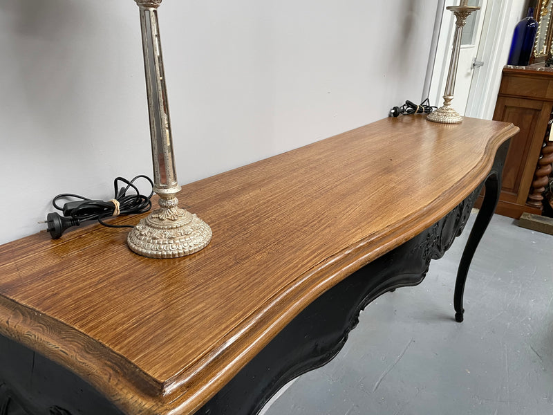 Louis XV style long console table with an ebonized black base and timber top. It is in good original detailed condition and has been sourced directly from France.