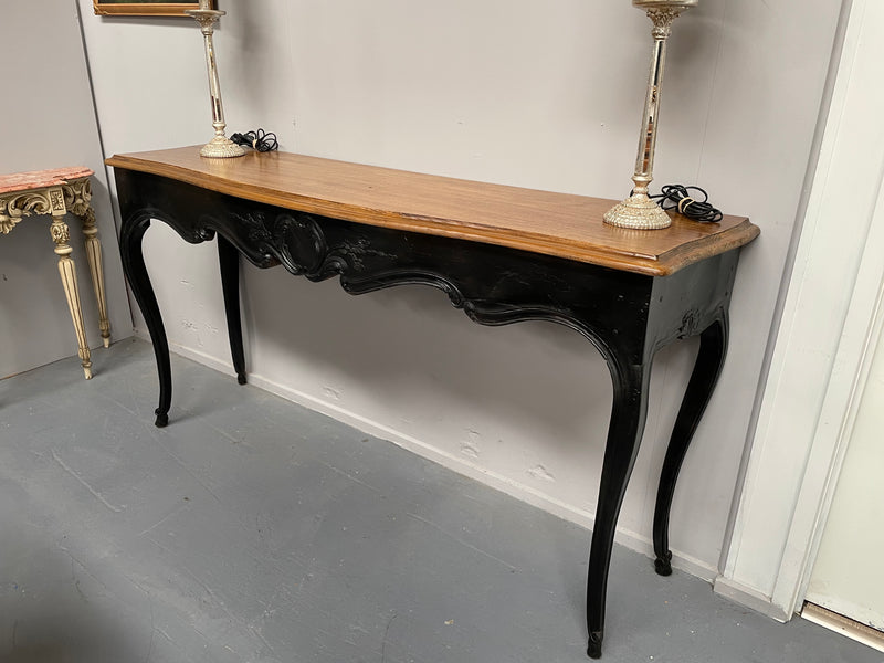 Louis XV style long console table with an ebonized black base and timber top. It is in good original detailed condition and has been sourced directly from France.