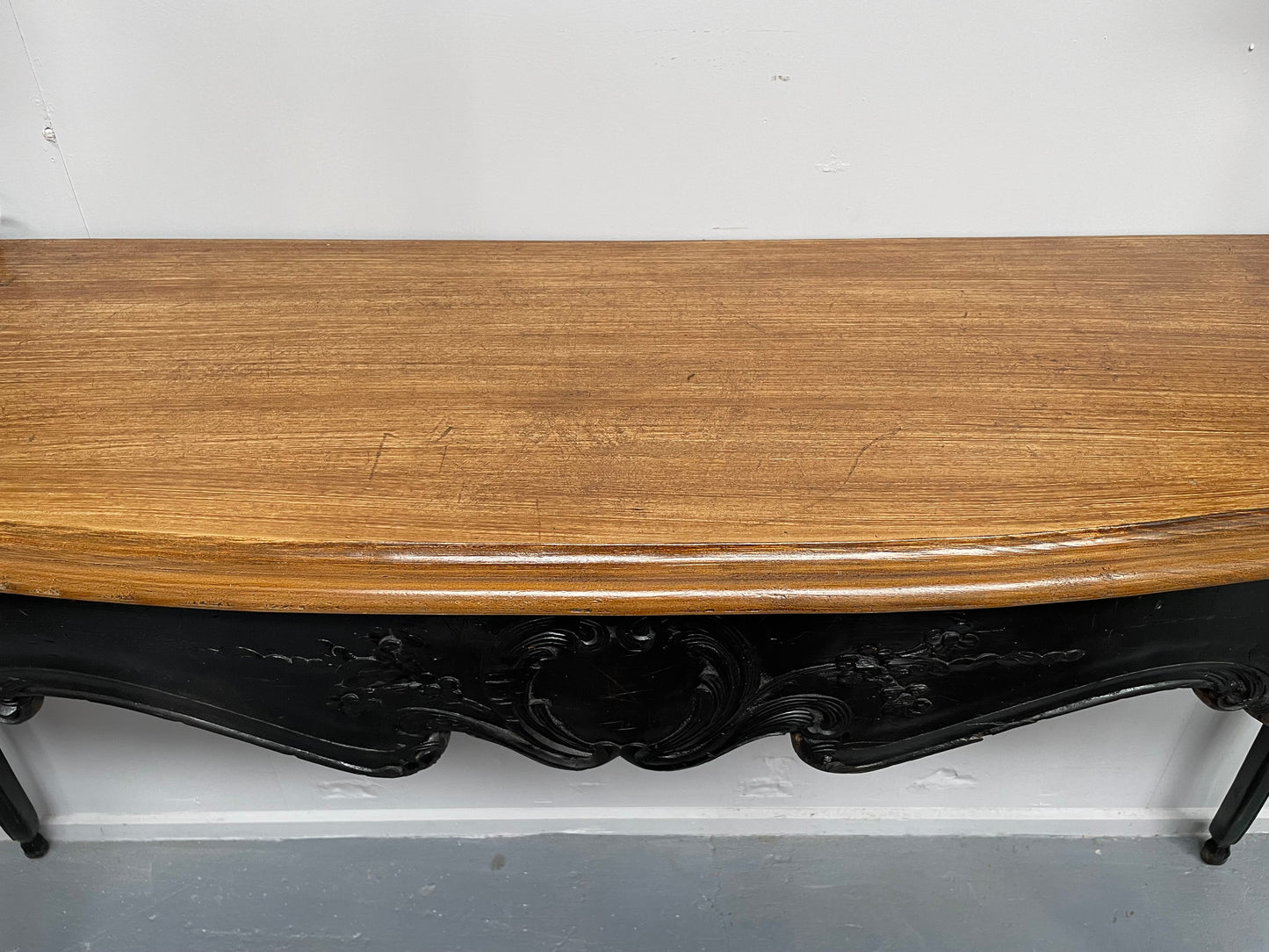 Louis XV style long console table with an ebonized black base and timber top. It is in good original detailed condition and has been sourced directly from France.