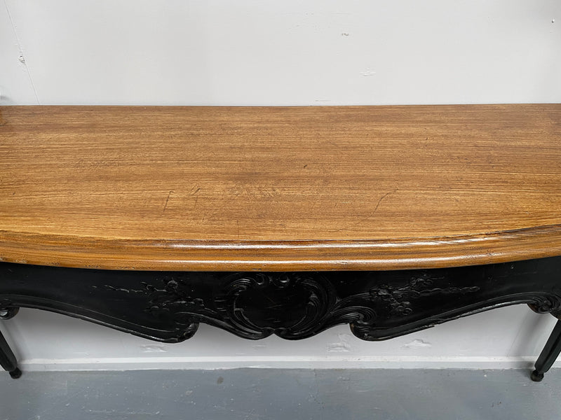 Louis XV style long console table with an ebonized black base and timber top. It is in good original detailed condition and has been sourced directly from France.