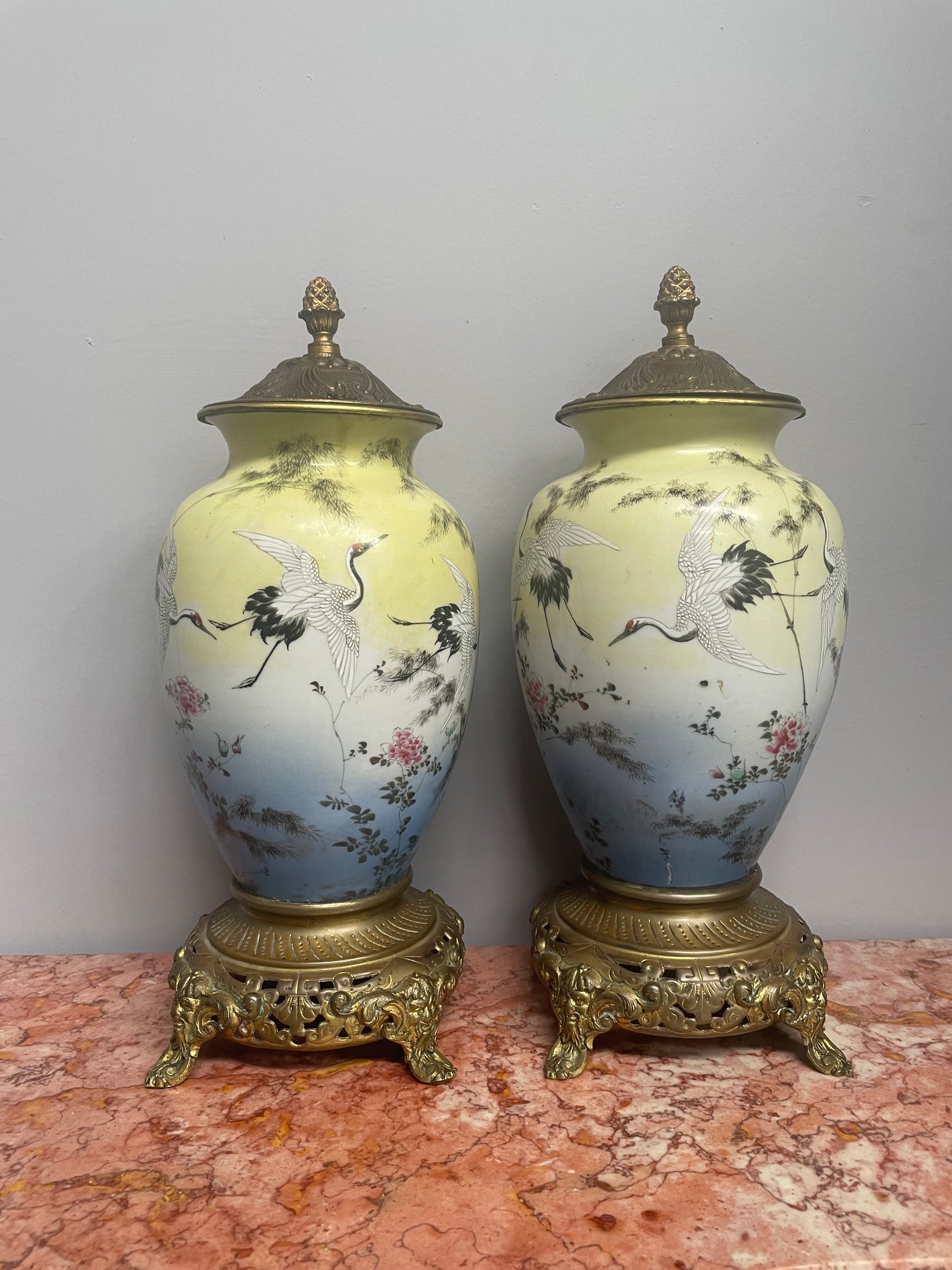 Attractive pair of Japanese urns. Hand painted depicting cranes and with brass mounts. In good original condition. Please see photos as they form part of the description.