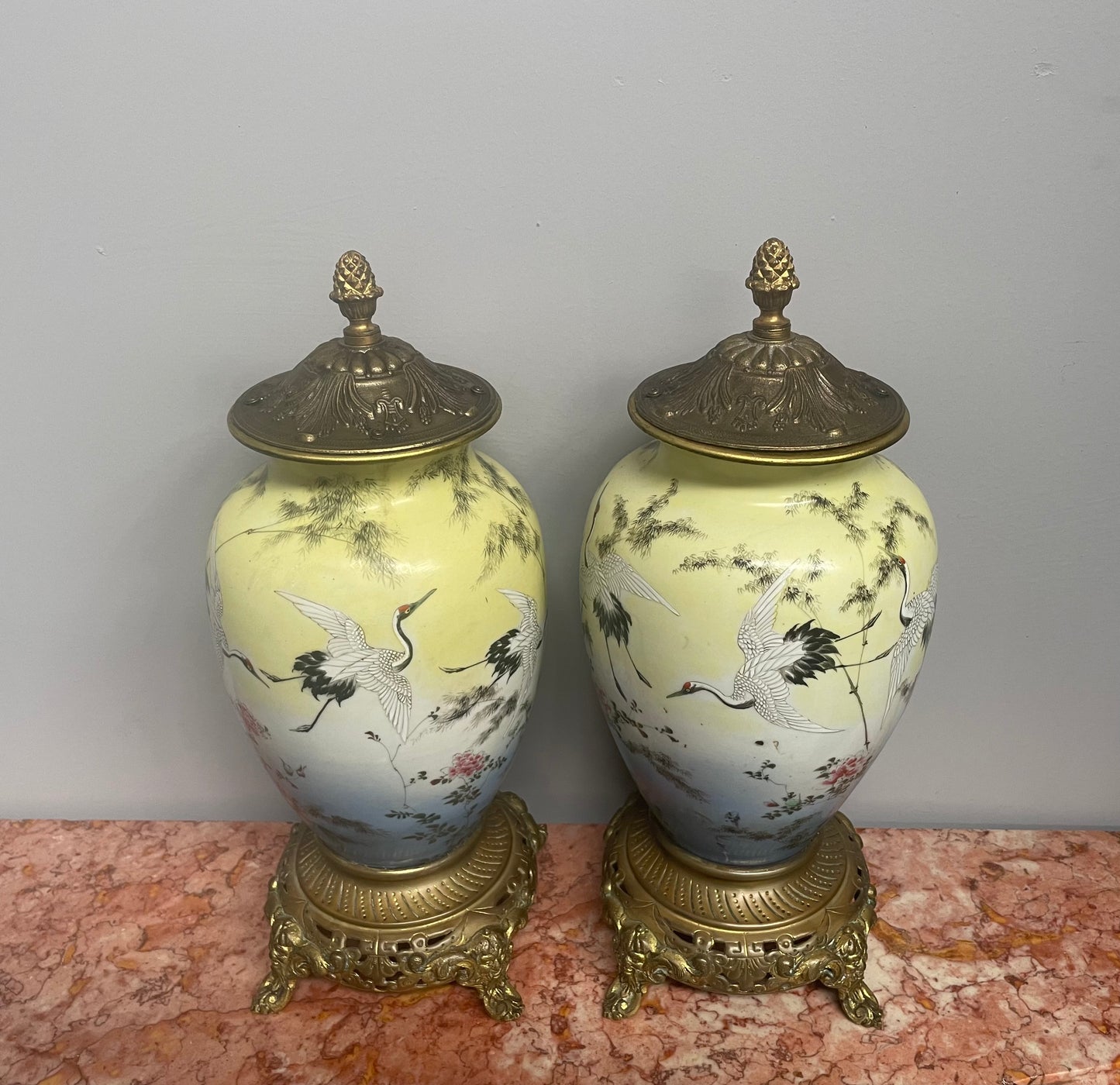 Attractive pair of Japanese urns. Hand painted depicting cranes and with brass mounts. In good original condition. Please see photos as they form part of the description.