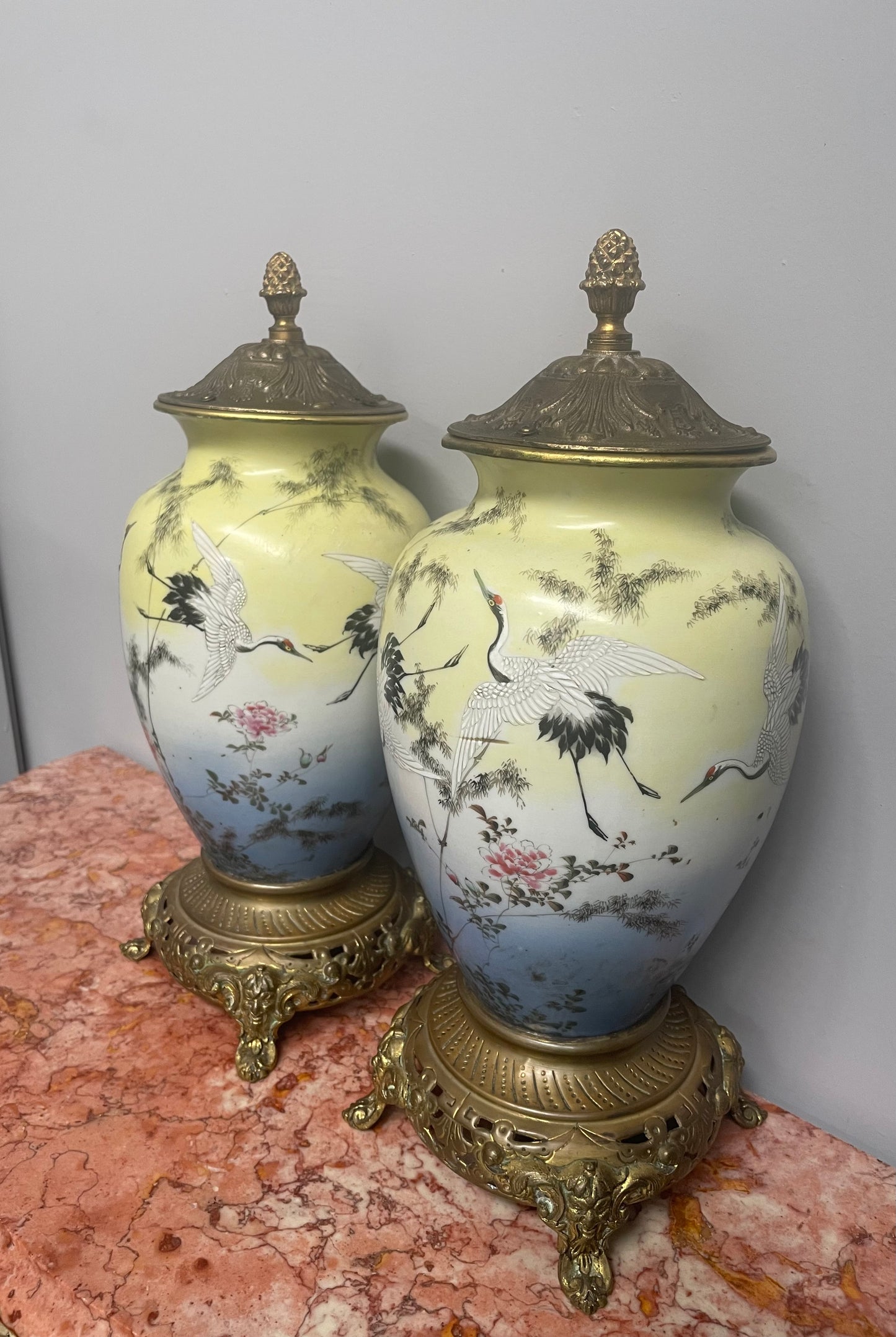 Attractive pair of Japanese urns. Hand painted depicting cranes and with brass mounts. In good original condition. Please see photos as they form part of the description.