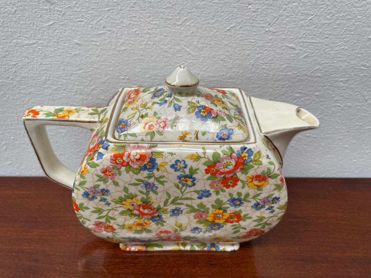 Empire made in England teapot With floral pattern. Marked underneath and is in good original used condition with no chips. Please view photos as they help form part of the description.