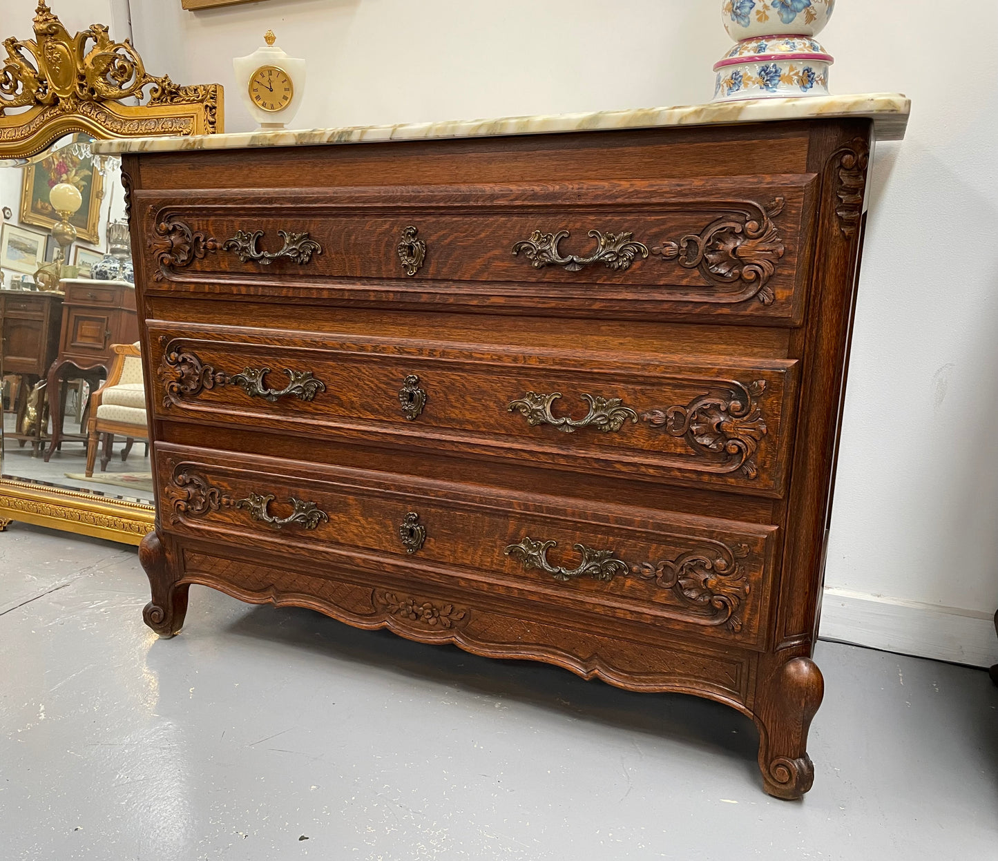 Louis XV style three drawer commode. Featuring carving on all three drawers with elegant bronze handles and escutcheons. It has an impressive marble top and has been sourced directly from France. It is in good original detailed condition.