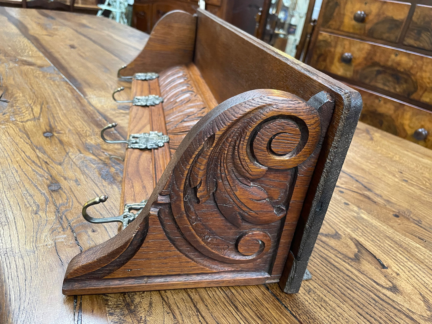 French oak wall coat rack with four decorative hooks and shelf. It has been sourced from France and is in good original condition.