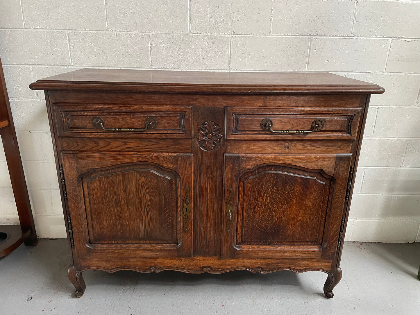 Charming French Oak provincial two door buffet. It has two drawers and a cupboard with two doors and one shelf. It is in good original condition and has been sourced directly from France.