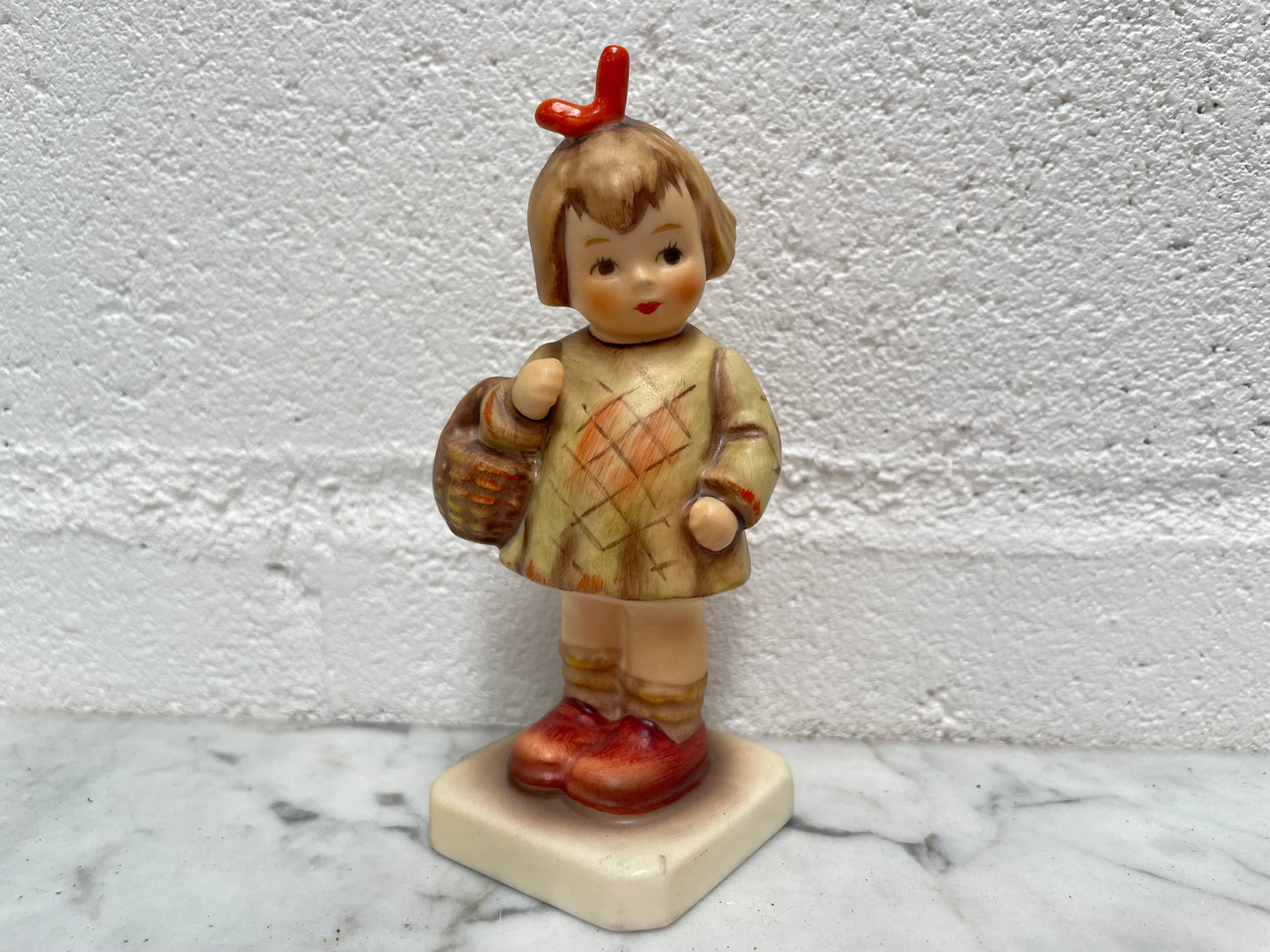 Beautiful Hummel Figurine "I Bought You a Gift", of a girl with her basket. In good original condition. Please see photos as they form part of the description.