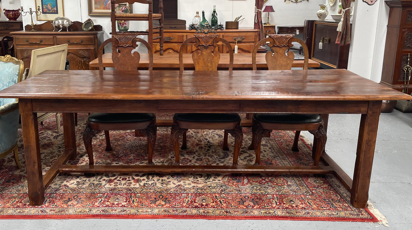 Rustic stretcher base dining table. The top consists of four heavy planks of French Oak timber. The surface is rustic and a little uneven and would require the use of place mats to even out. Please see photos as they form part of the description.