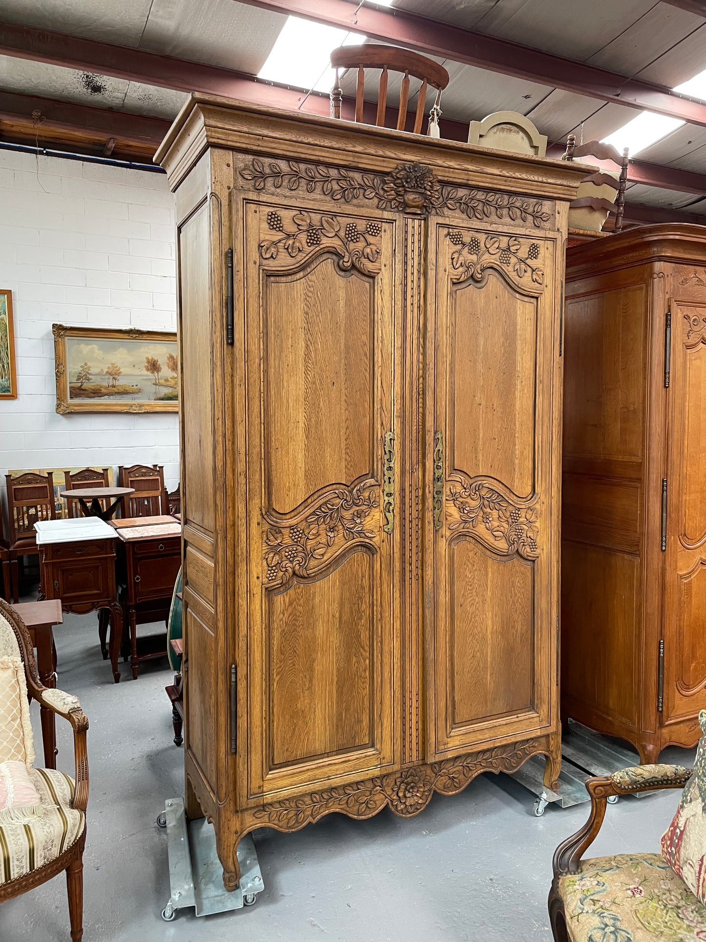 Attractive French Oak two door decoratively carved armoire with hanging space and adjustable/removable shelves. Imported directly from France and is in good original detailed condition.