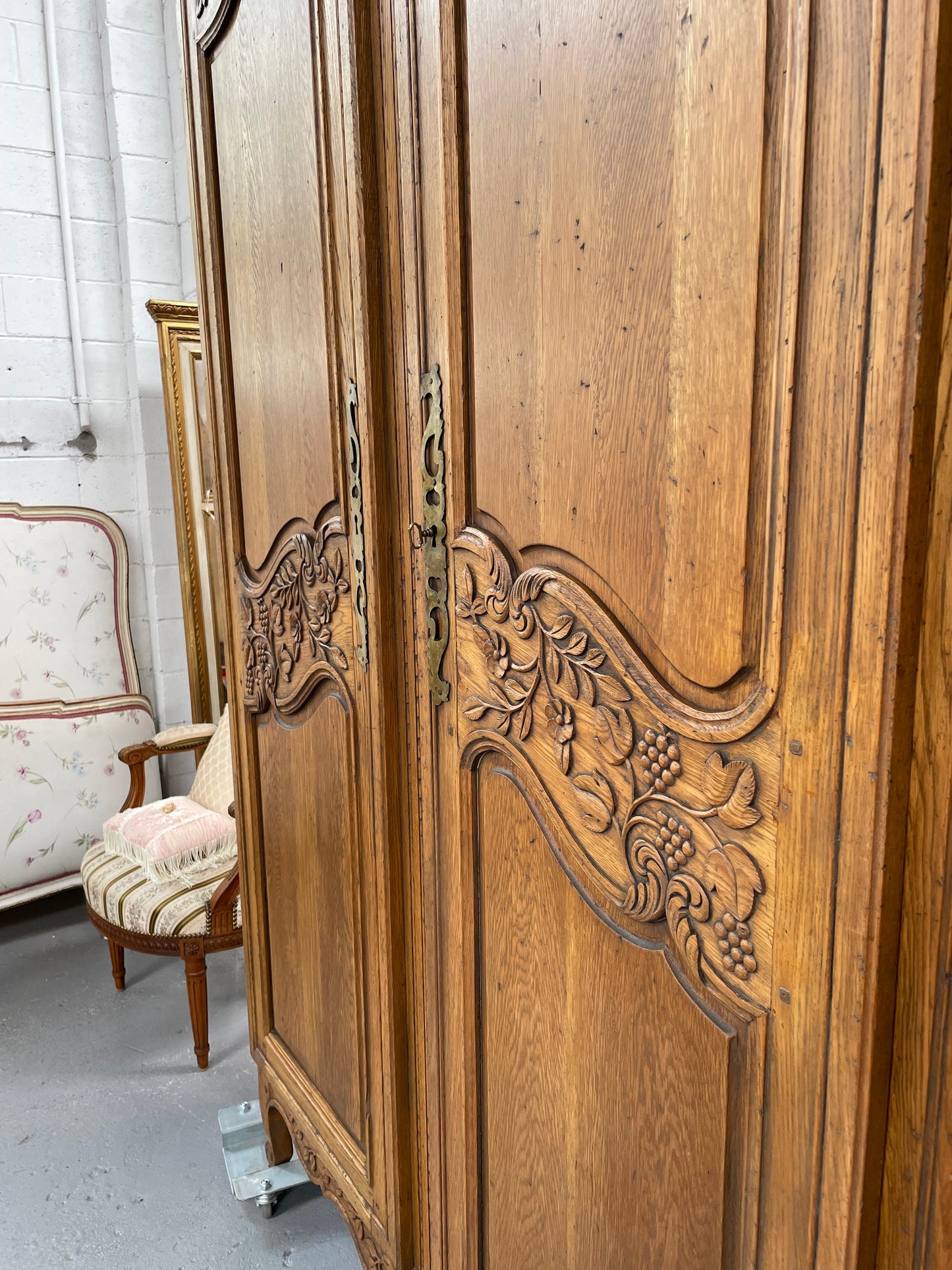 Attractive French Oak two door decoratively carved armoire with hanging space and adjustable/removable shelves. Imported directly from France and is in good original detailed condition.