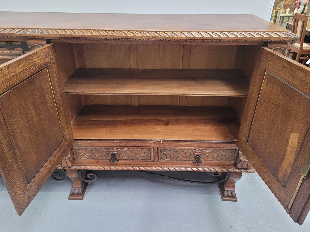 Large French Oak Renaissance style four door sideboard/buffet. Great decorative item with amazing carvings and stunning iron work on base. It is in good original detailed condition. Can pull apart completely making it easier to move.