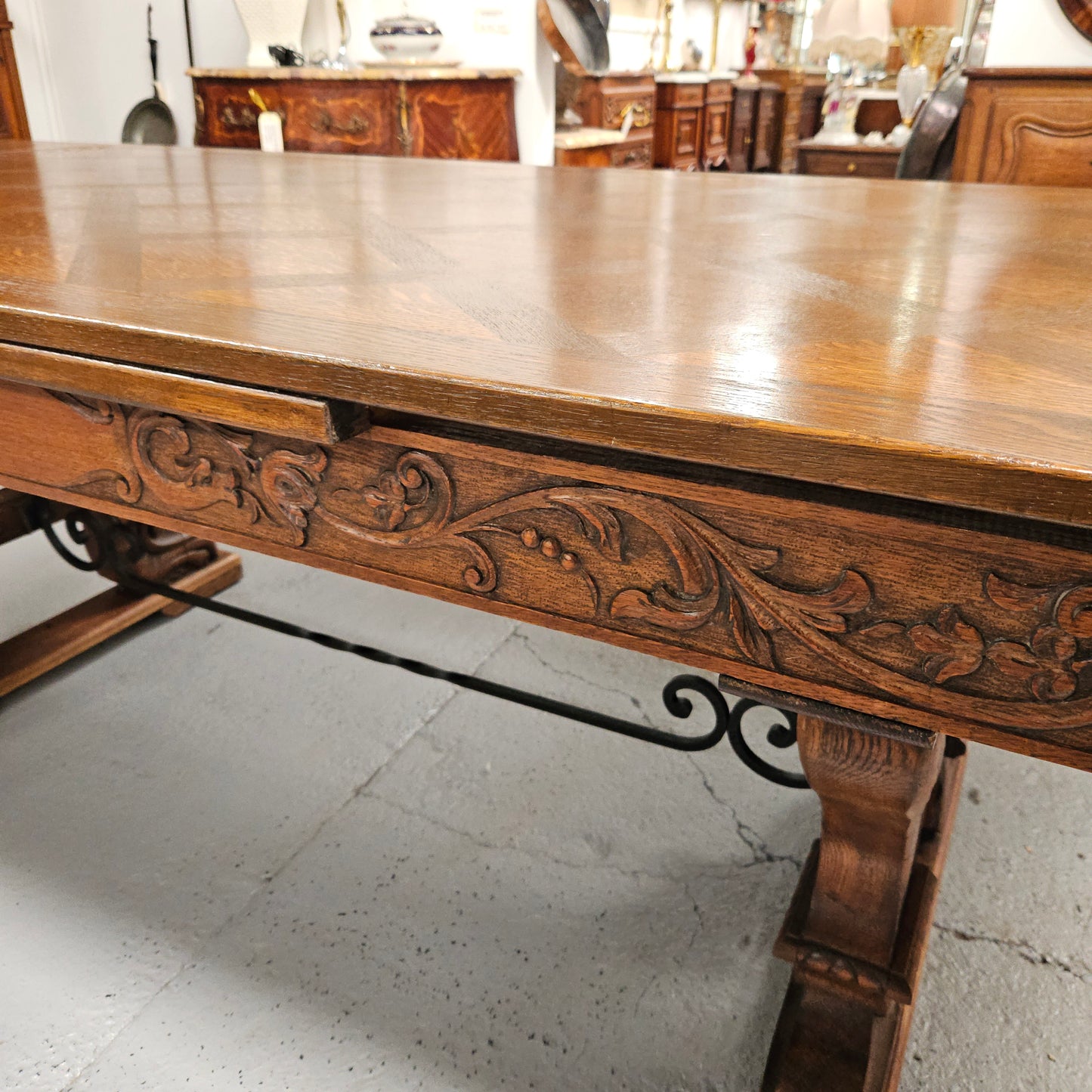 Beautiful French Oak Spanish style extension dining table with a decorative iron base and parquetry top. Lovely carvings on the legs and the skirt of the base. With the extensions closed it is 179.5 cm long and when fully extended it is 279 cm long.
