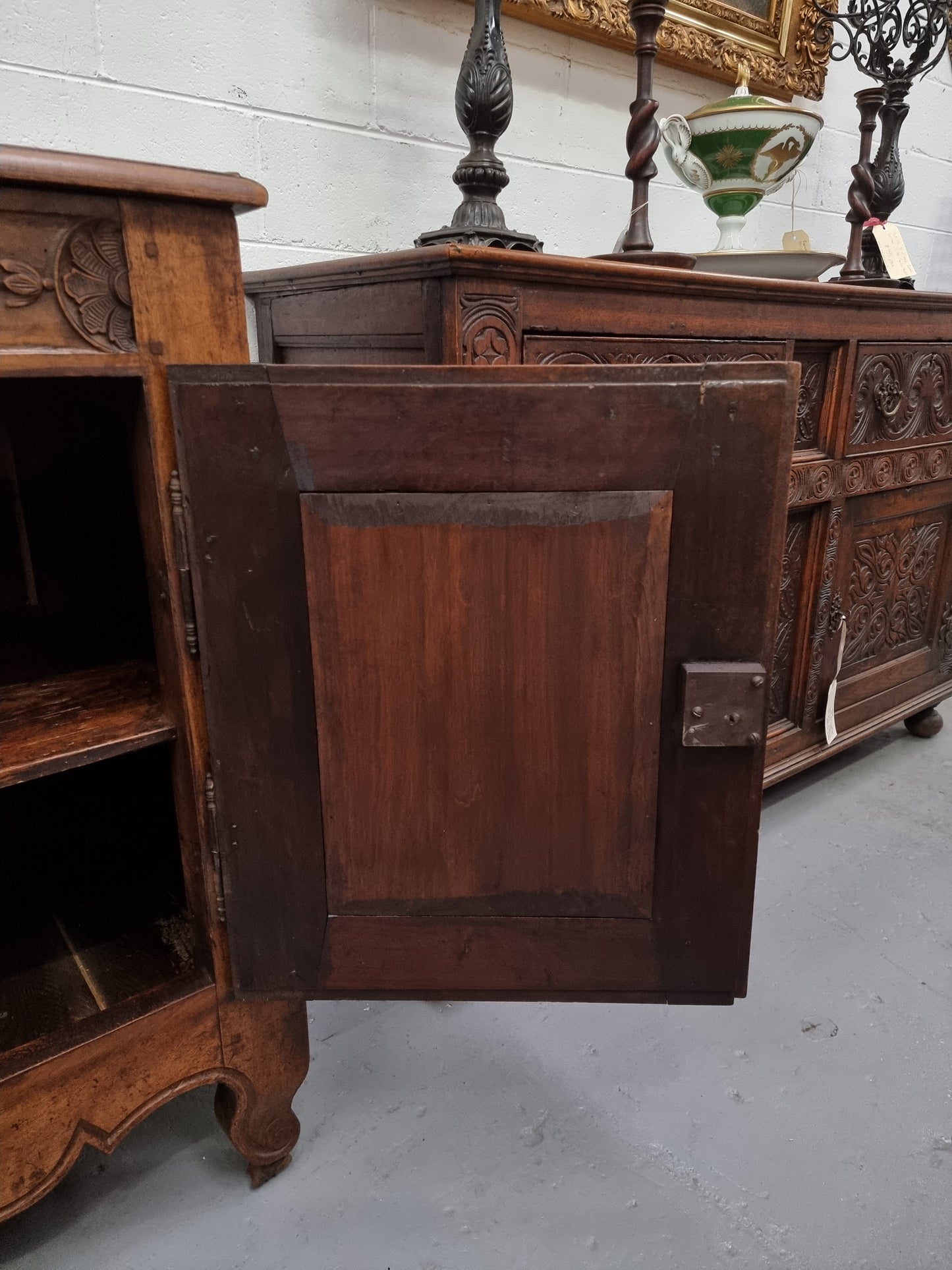 Vintage wooden cabinet with intricate carvings on a white floor.