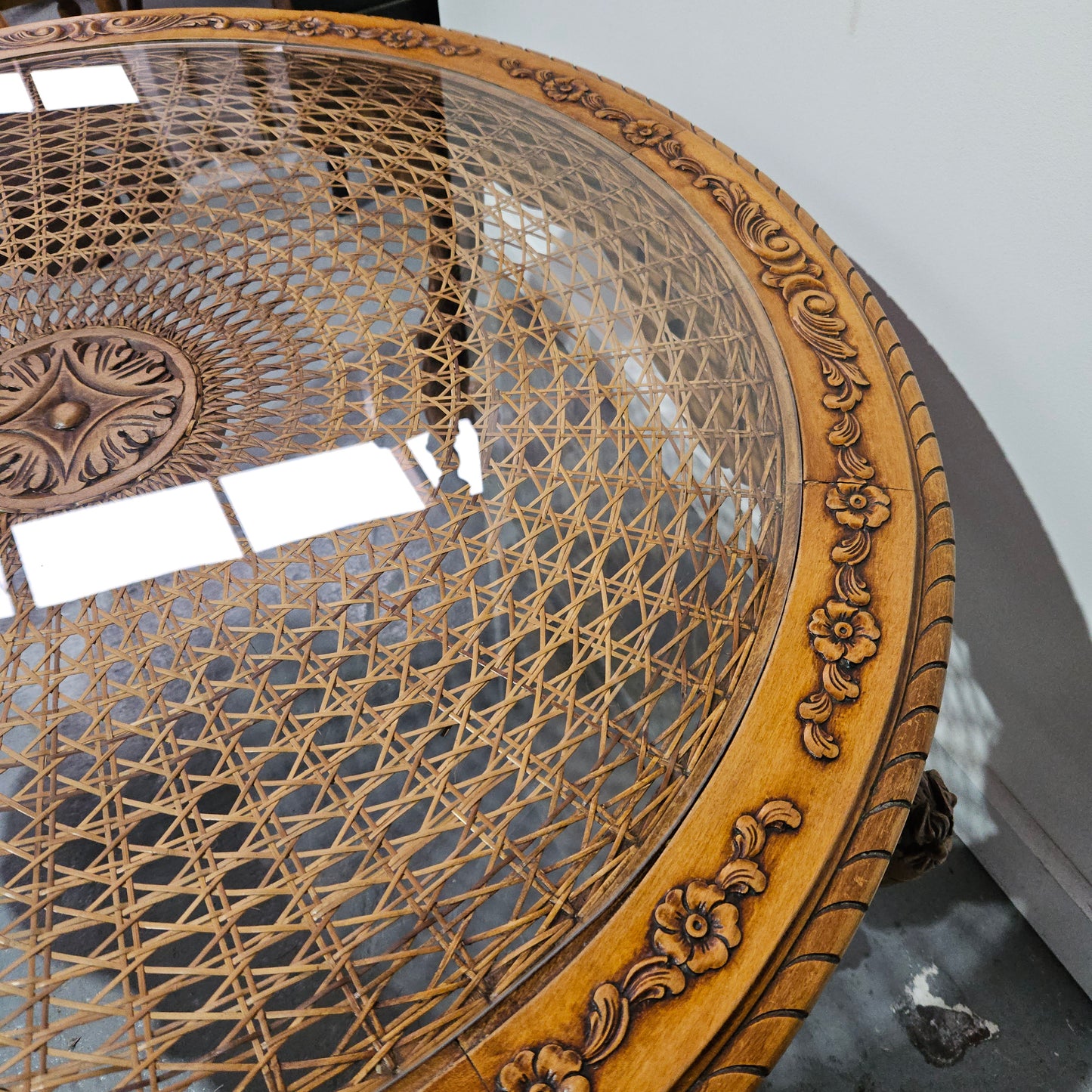 French oak Louis XV style round cane insert coffee table with highly decorative legs and table top. It has a glass cover to fit over the cane. It is in good original condition and has been sourced from France.