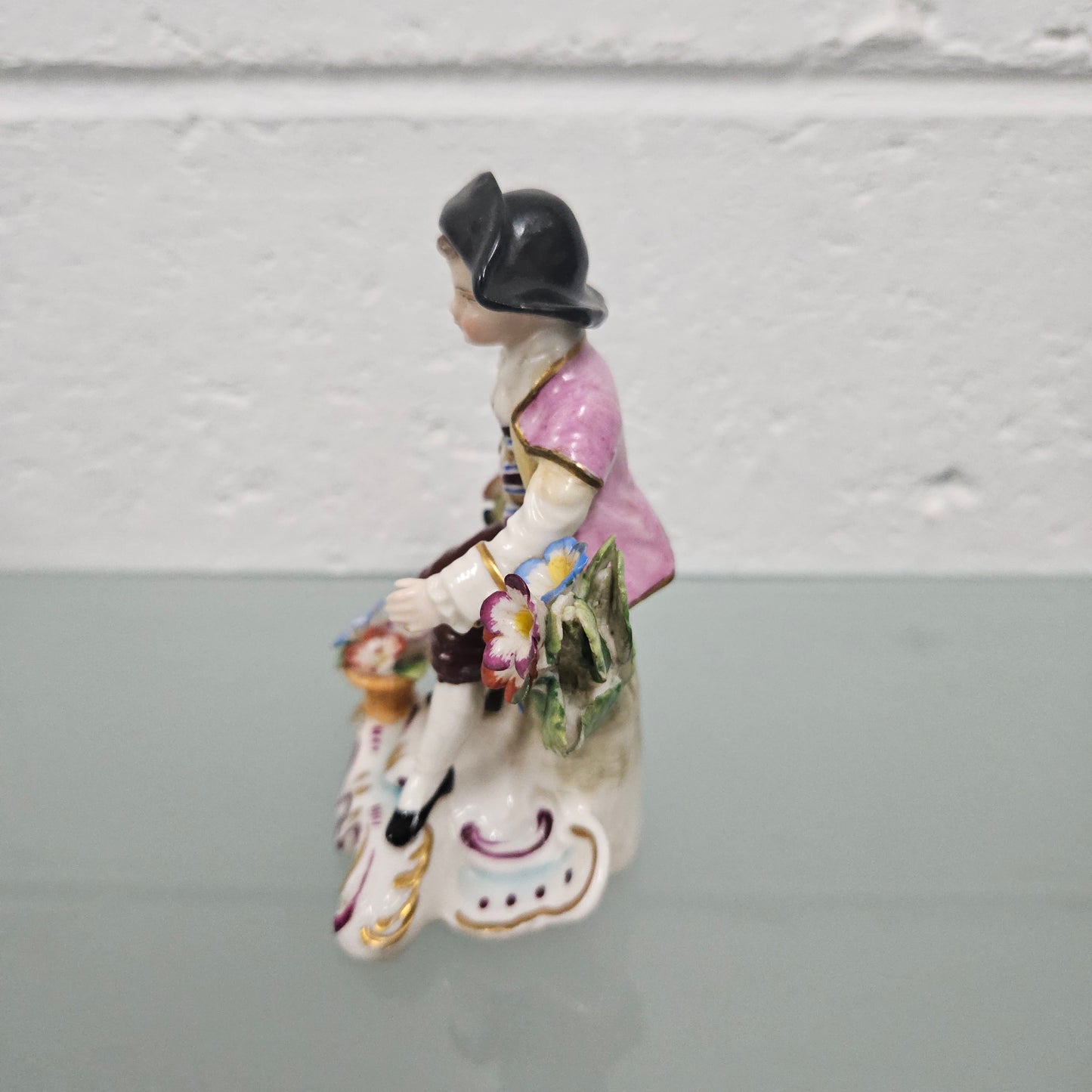 Stunning detailed early figure of a boy with flowers, there is a gold anchor mark to the back of the statue. It is in good original condition with some missing parts on the flowers as