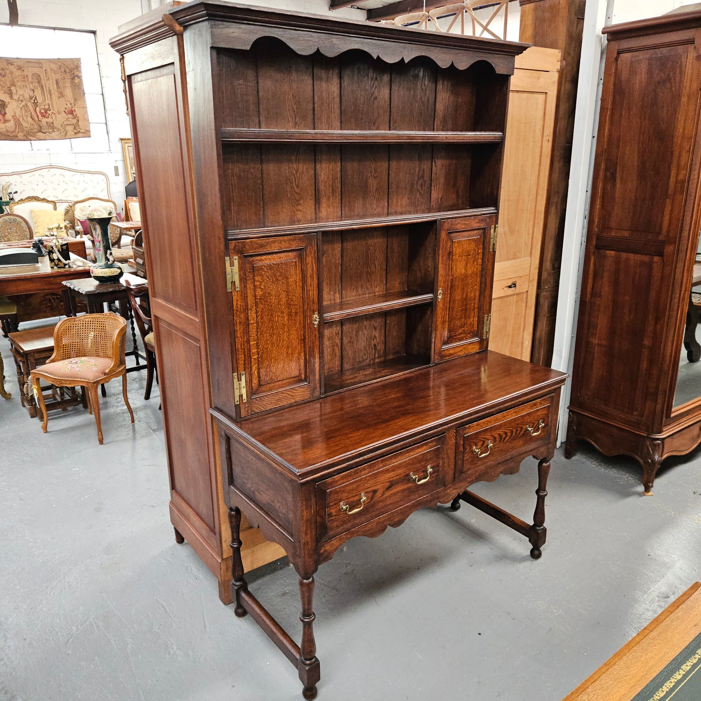 Late 18th century oak dresser consisting of separate base and top with four shelves, two drawers and two cupboards. Medium proportions and in good original detailed condition.