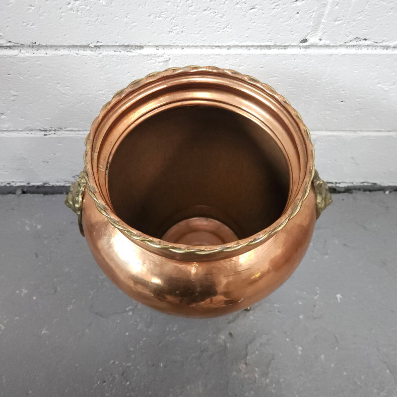 Lovely copper and brass pot with lions heads on the handles and lions feet on the base. It is in good original condition.