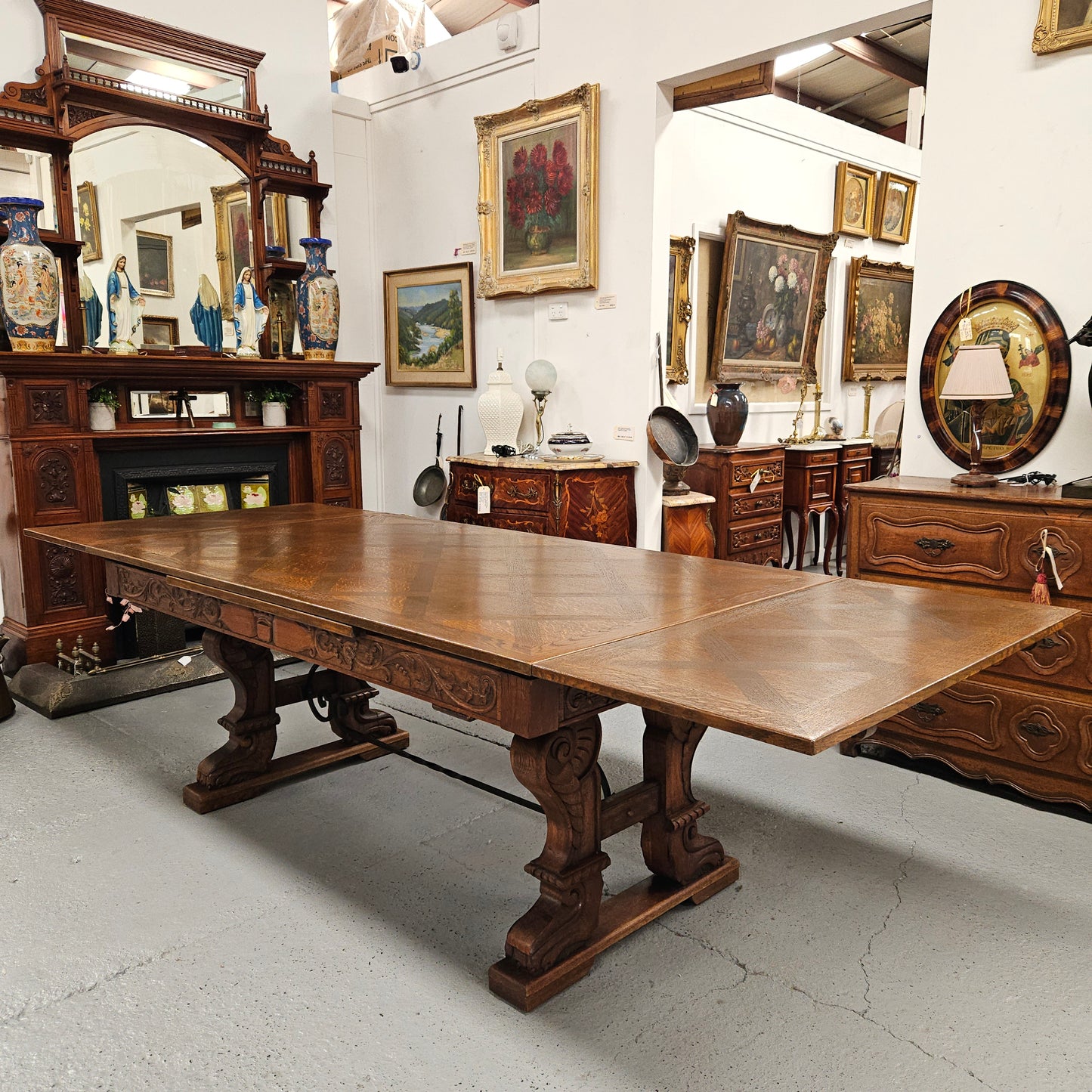 Beautiful French Oak Spanish style extension dining table with a decorative iron base and parquetry top. Lovely carvings on the legs and the skirt of the base. With the extensions closed it is 179.5 cm long and when fully extended it is 279 cm long.